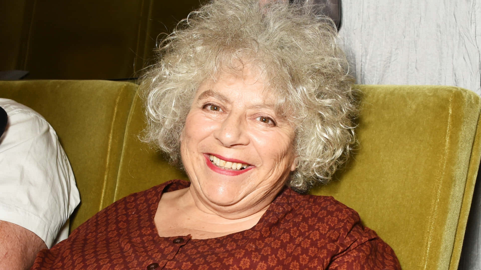 Miriam Margolyes, curly gray hair, mustard green velvet couch, Full HD Desktop Wallpaper