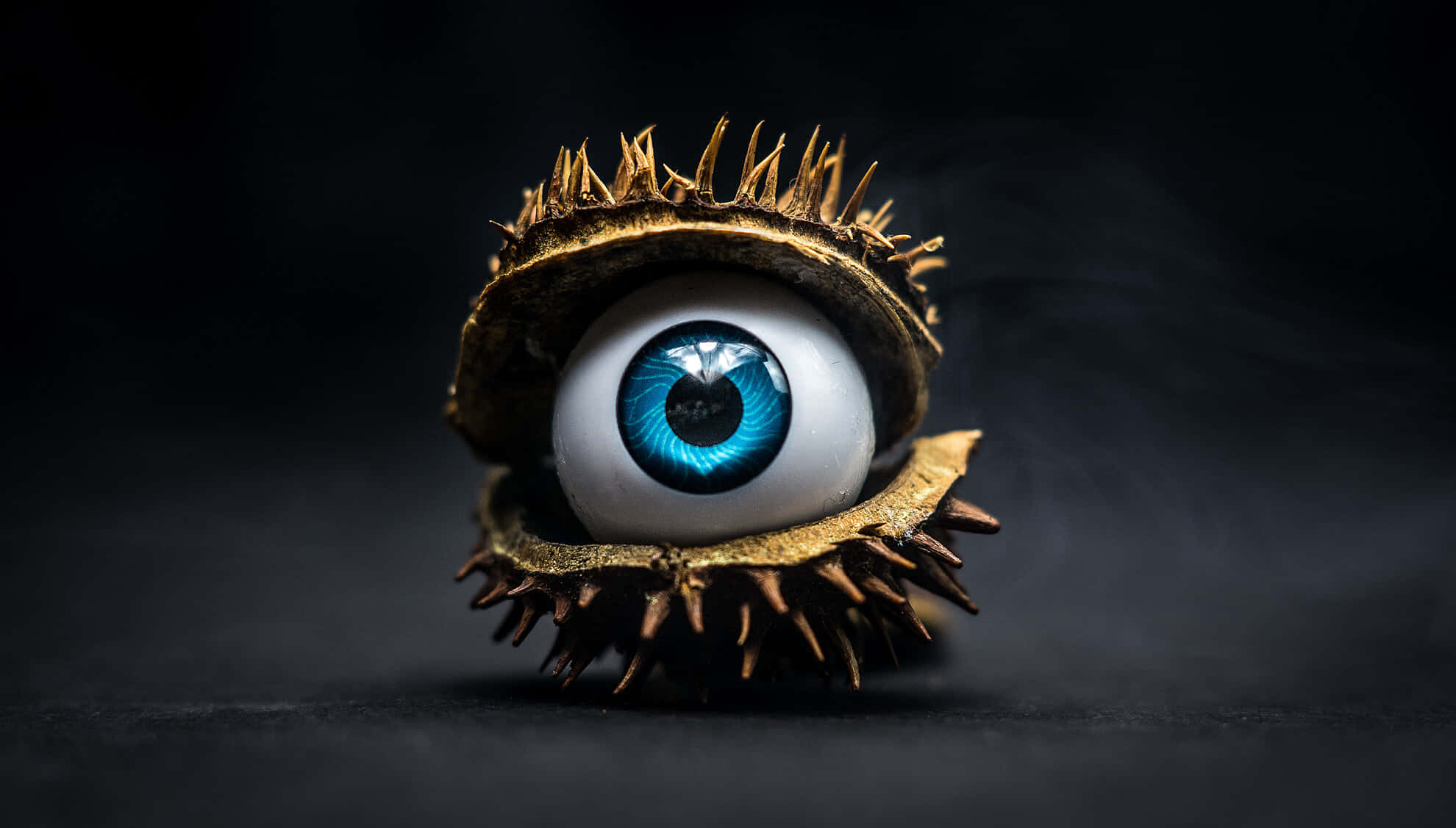 surreal blue eyeball, spiky golden chestnut shell, dark smoky background, Full HD Desktop Wallpaper