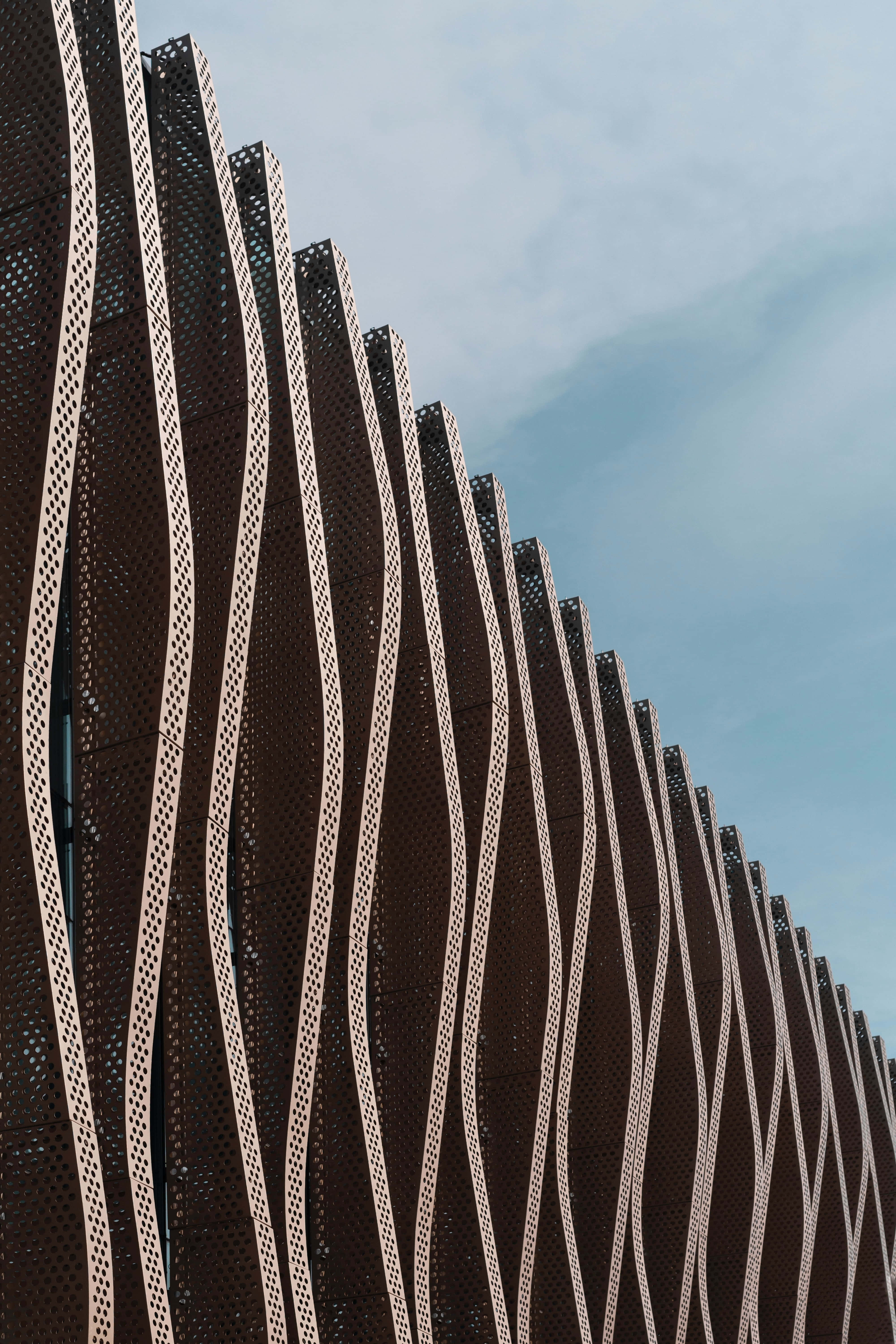modern iPhone, pale blue sky, wavy perforated metal panels, 5K Phone Wallpaper