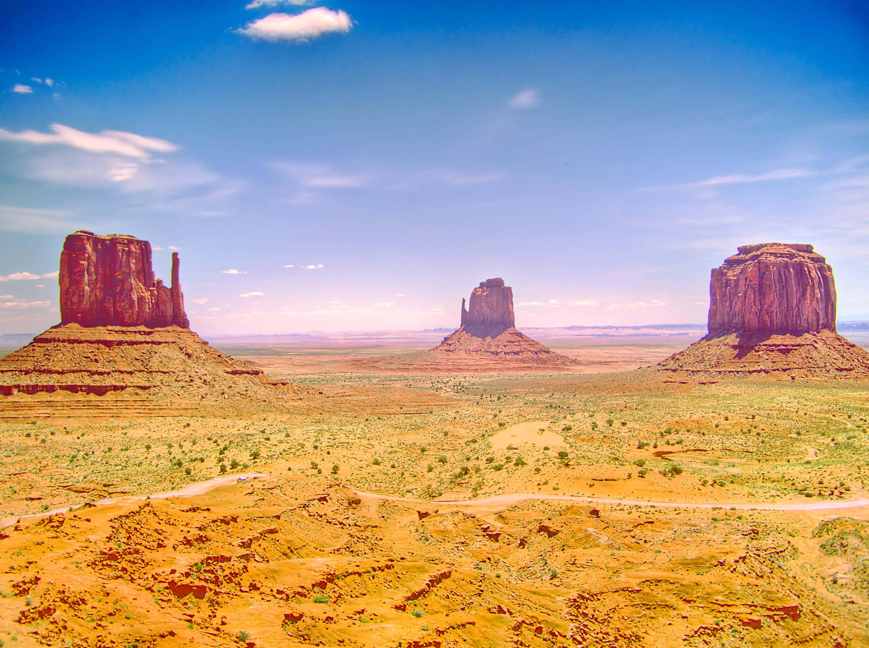 Monument Valley Navajo Tribal Park, red rock buttes, bright blue sky, 2K Desktop Wallpaper