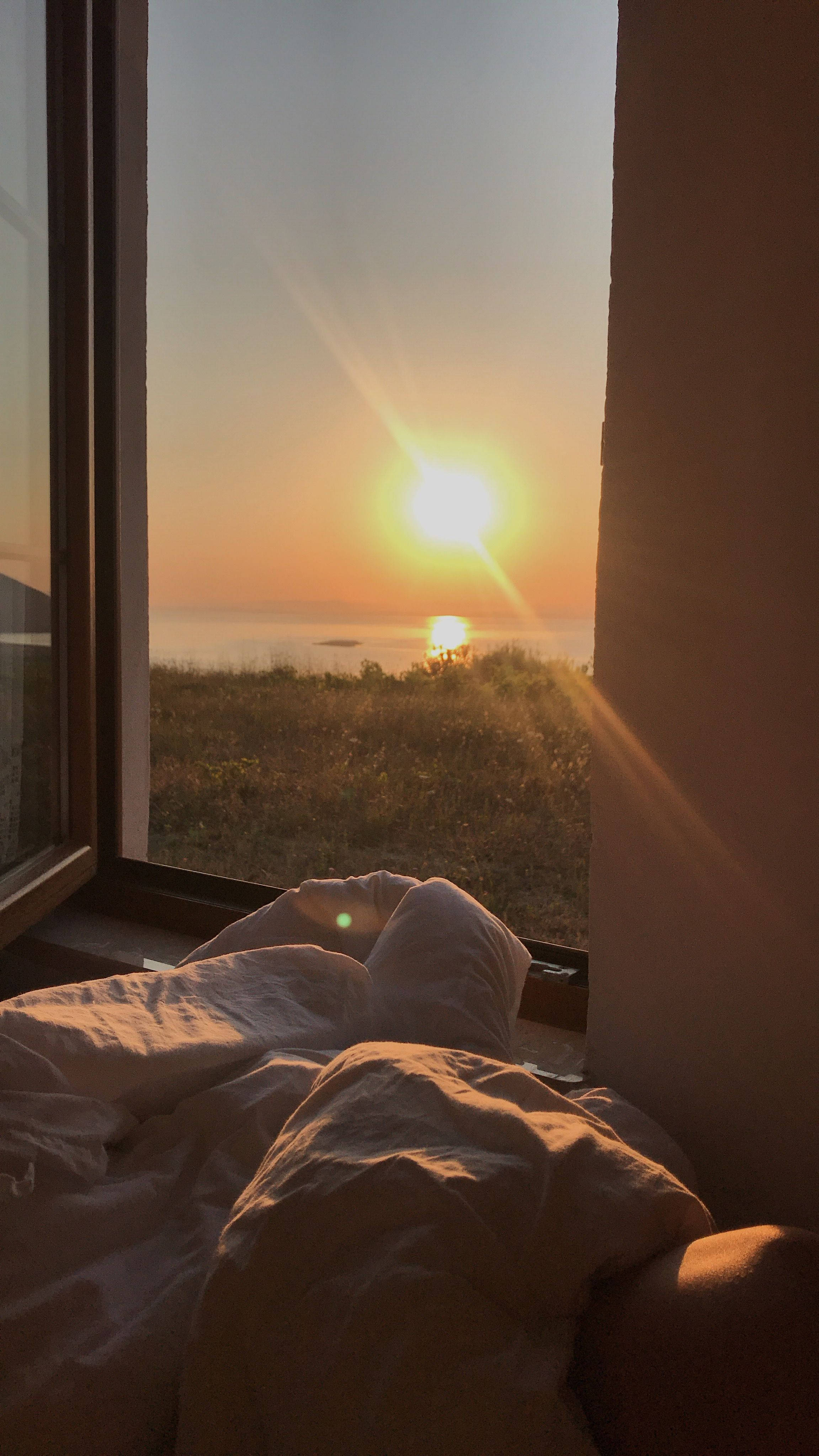 Sunset, grassy hill, distant sea, 4K Phone Wallpaper