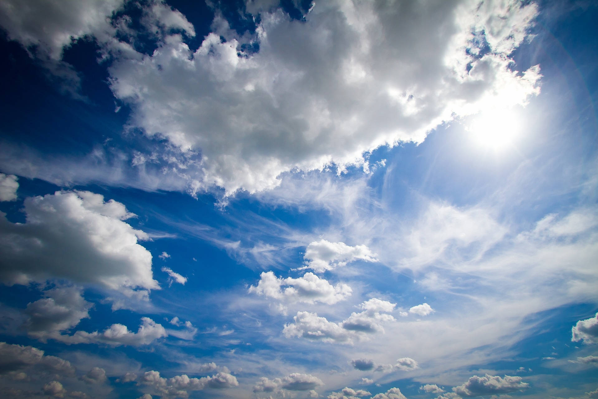 Vibrant blue sky, fluffy white clouds, bright sun rays, Full HD Desktop Wallpaper