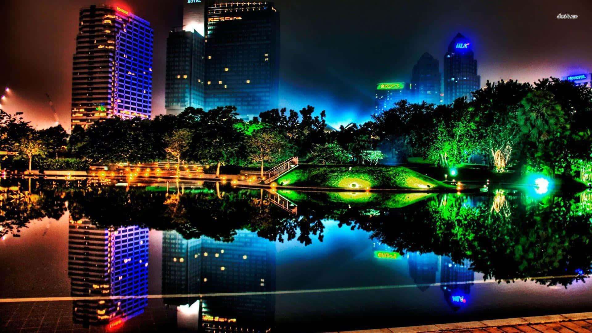 nighttime cityscape, illuminated skyscrapers, lush green trees, Full HD Desktop Wallpaper