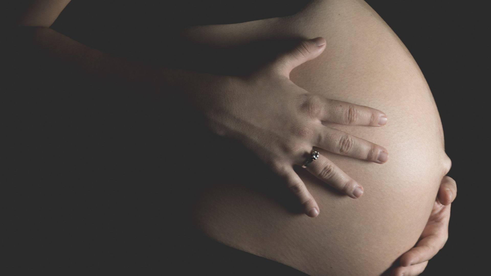 pregnant belly, hand with a ring, dark background, Full HD Desktop Wallpaper