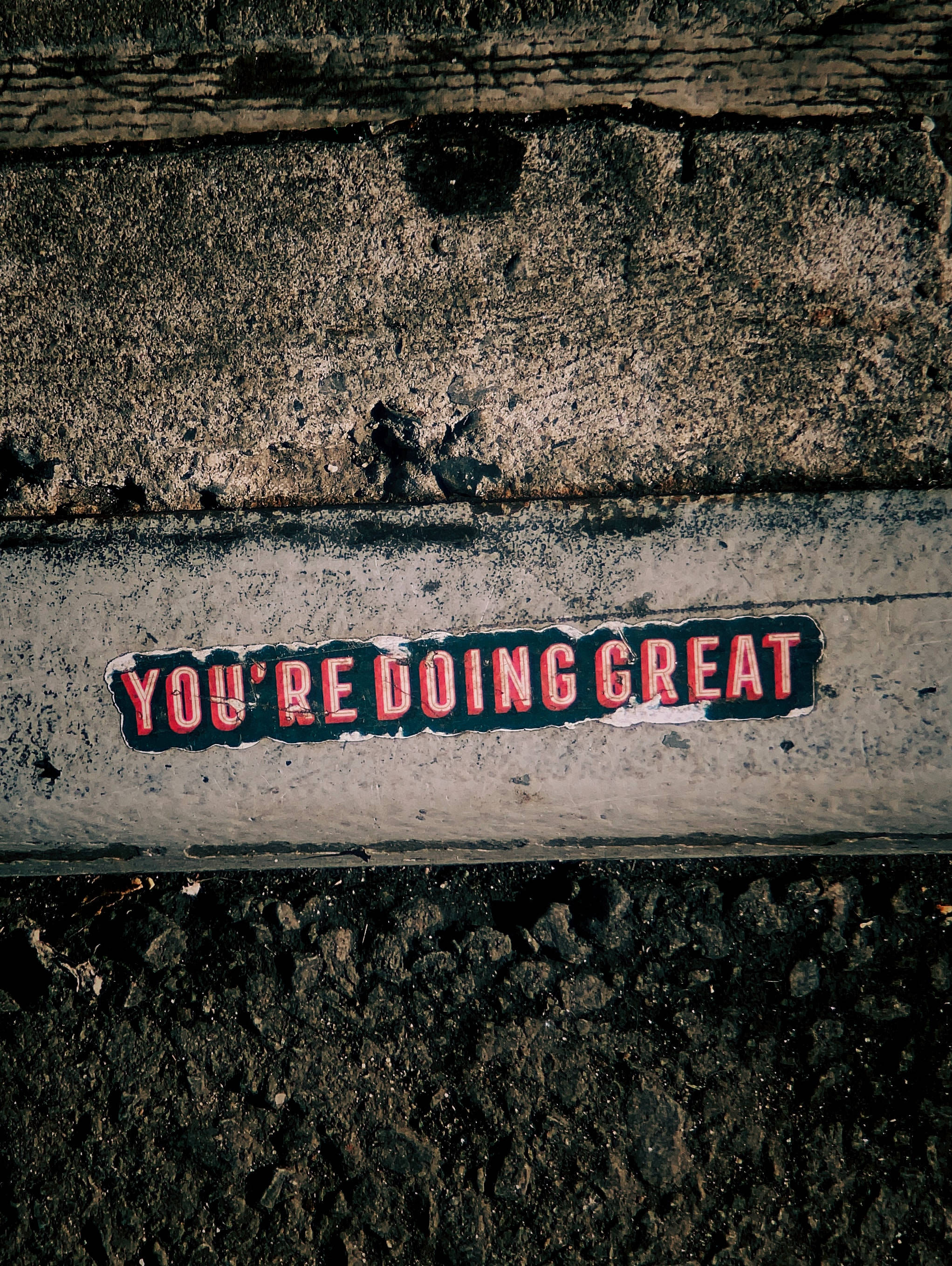 YOU'RE DOING GREAT, weathered red sticker, concrete ledge, 2K Phone Wallpaper