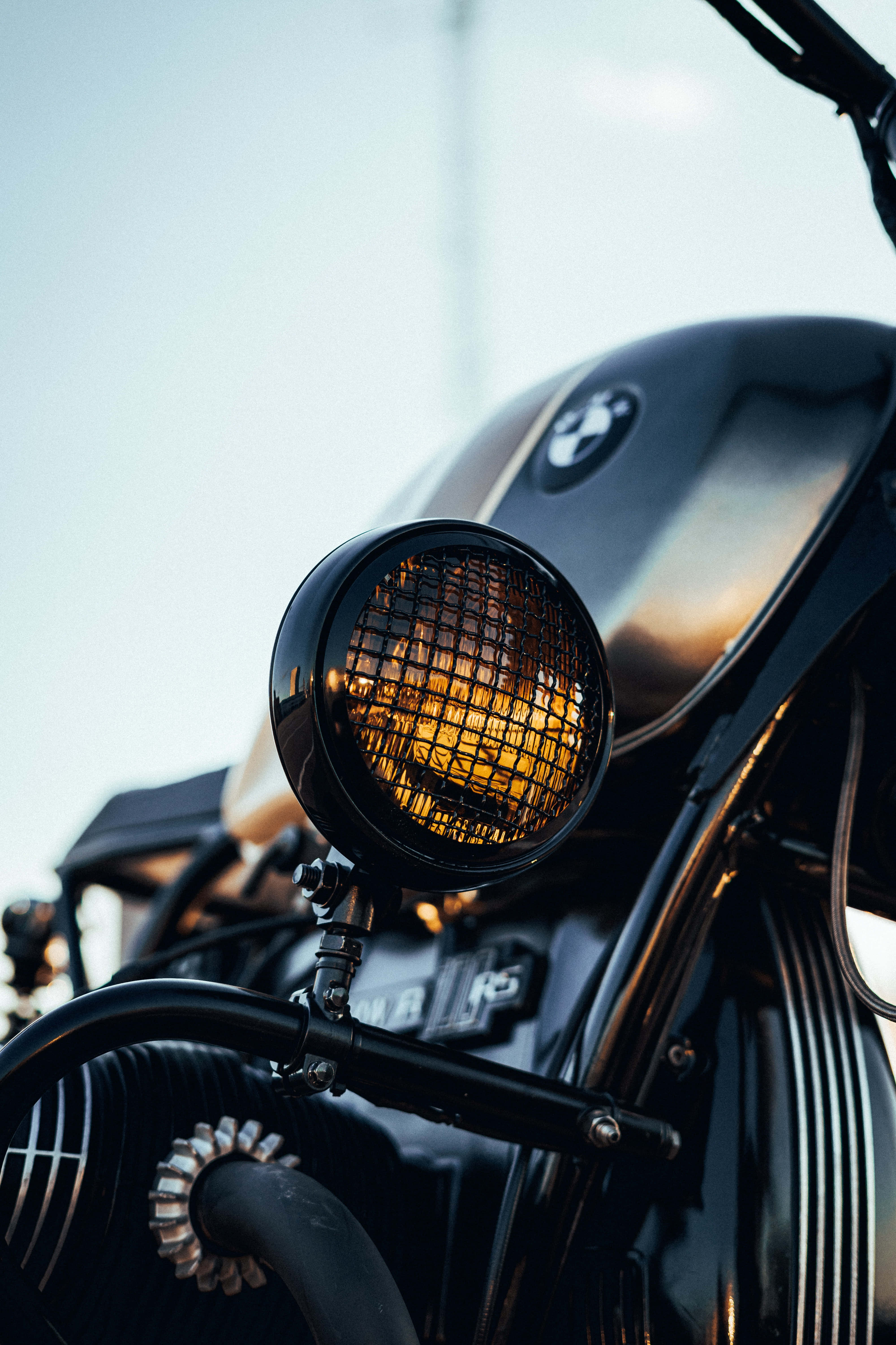 classic black motorcycle, round headlight, glowing warmly, 5K Phone Wallpaper