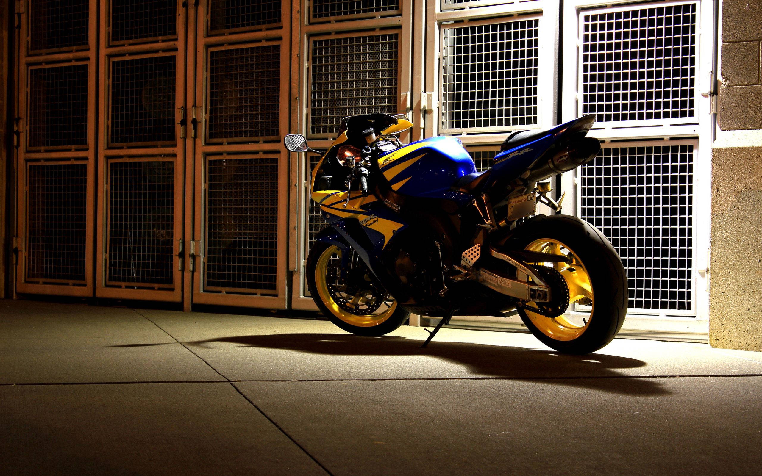 blue and yellow sport motorcycle, night, metal grid doors, 2K Desktop Wallpaper