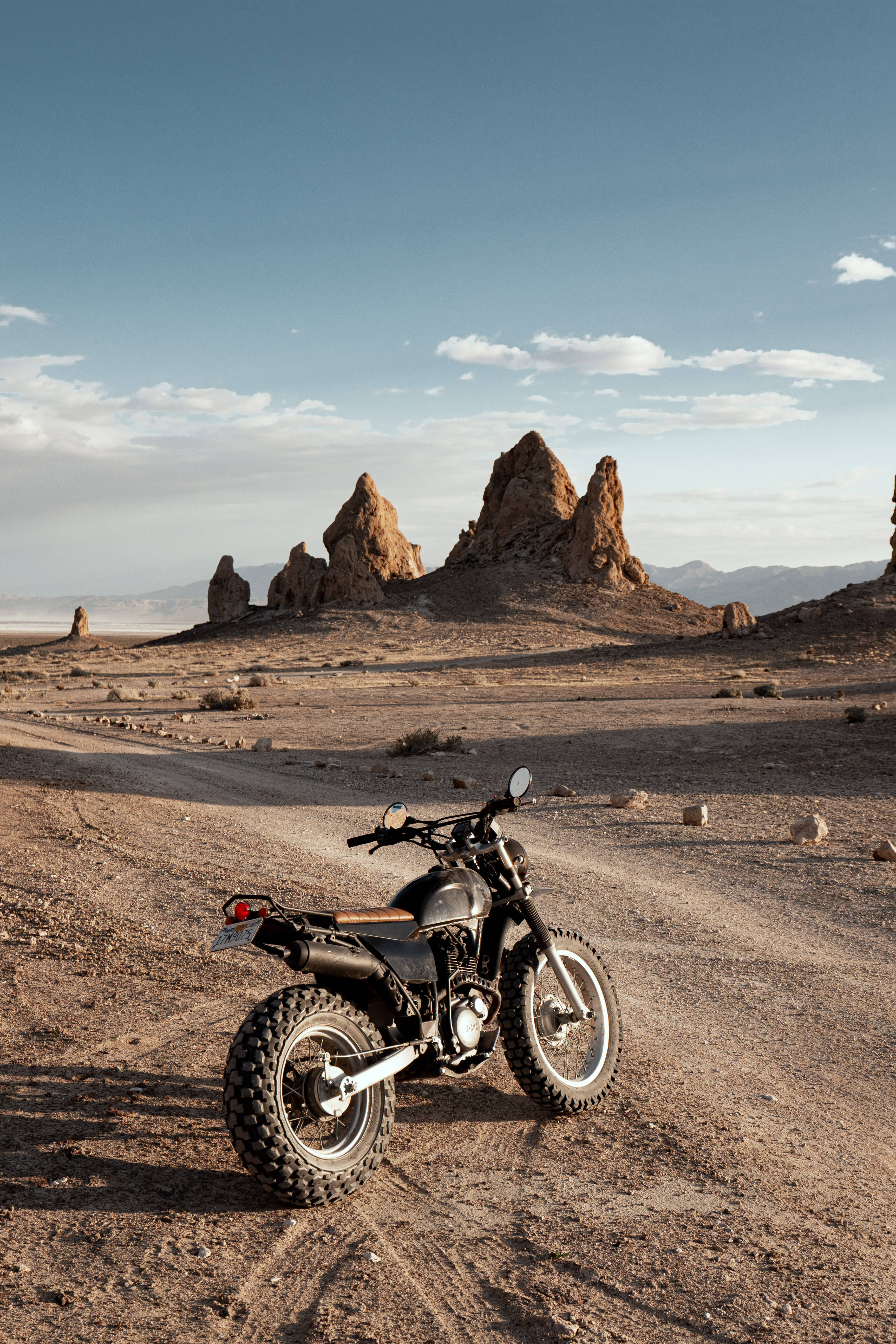 black dirt bike, dusty trail, vast blue sky, 5K Phone Wallpaper