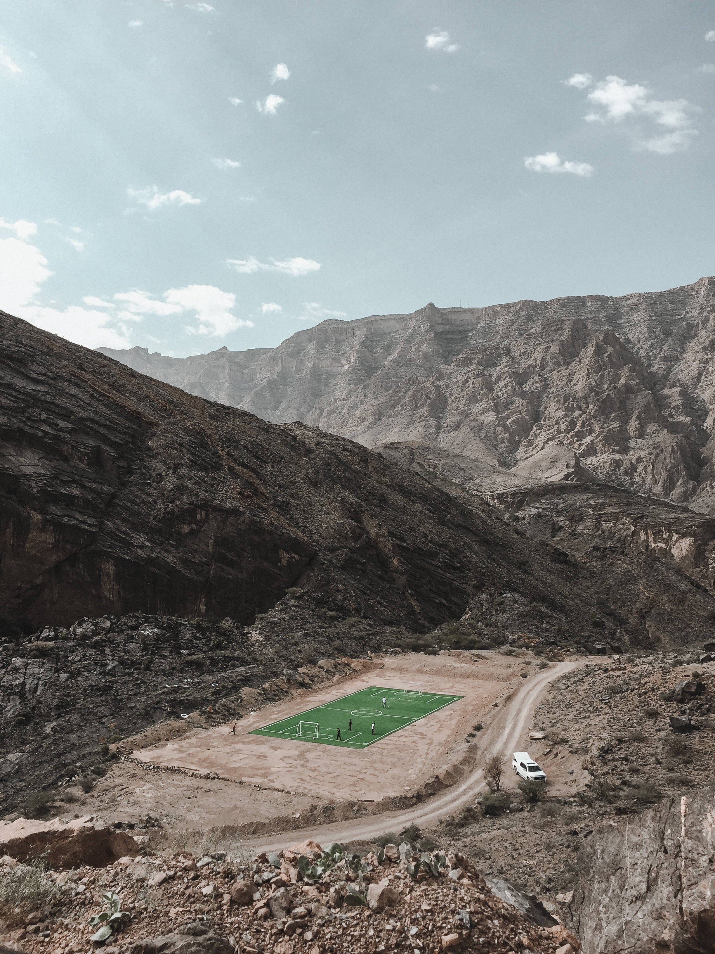 mountain range, football stadium, vibrant green soccer field, 2K Phone Wallpaper