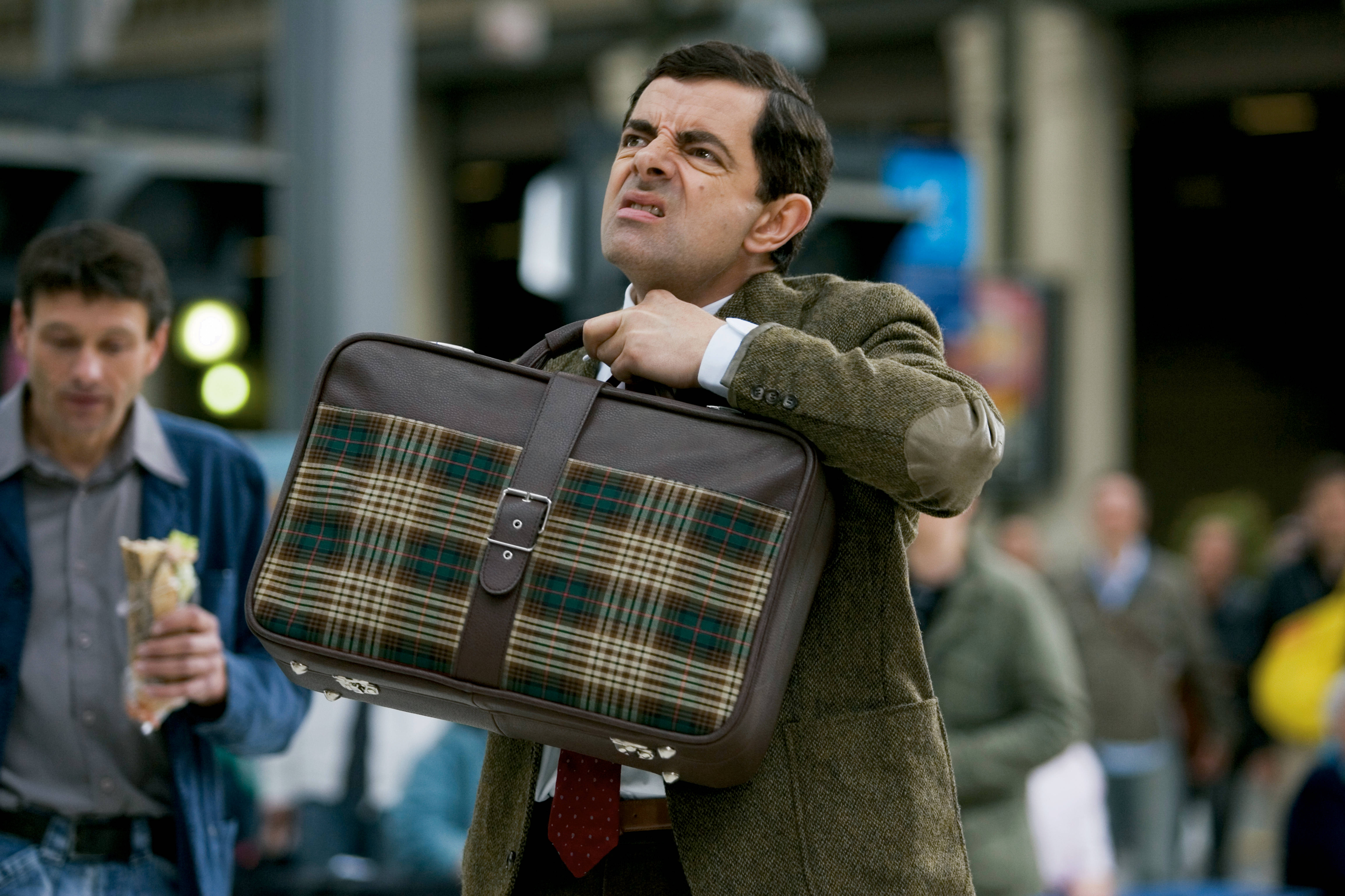 Mr Bean, plaid suitcase, bustling urban station, 5K Desktop Wallpaper