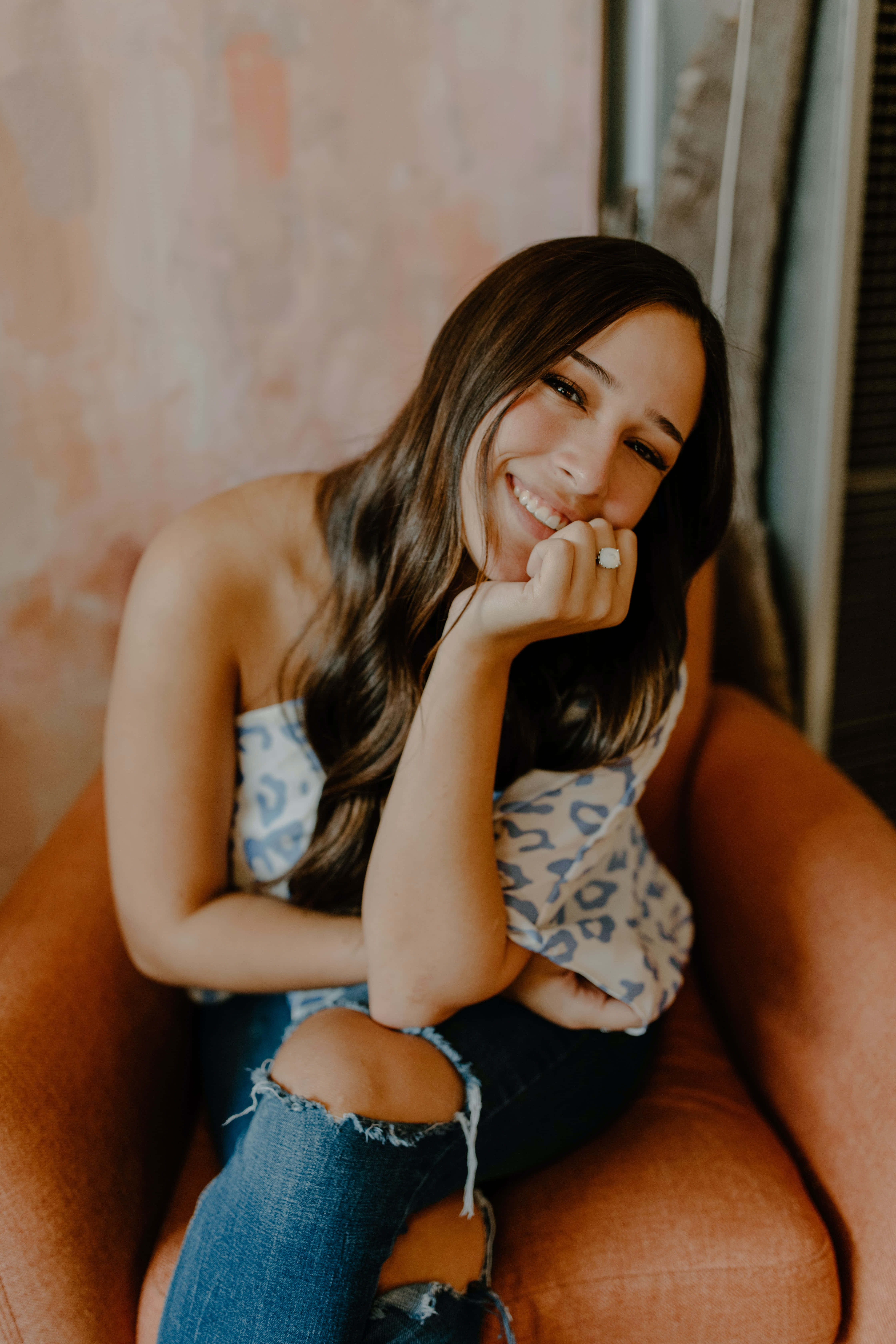 Mujer Soltera, long dark hair, warm-toned armchair, 5K Phone Wallpaper
