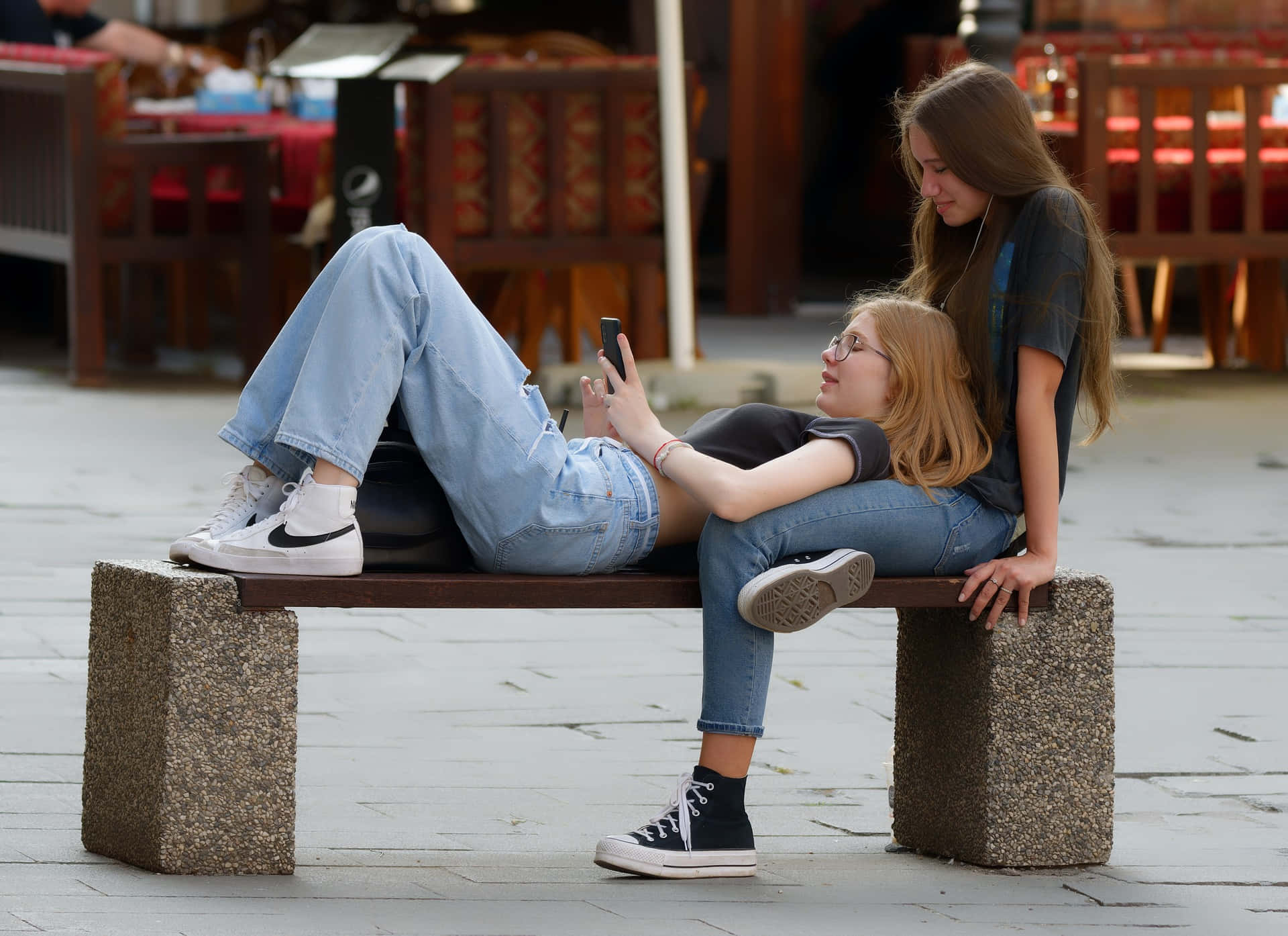 Mujeres Lesbianas, stone bench, sunlit outdoor cafe, Full HD Desktop Wallpaper