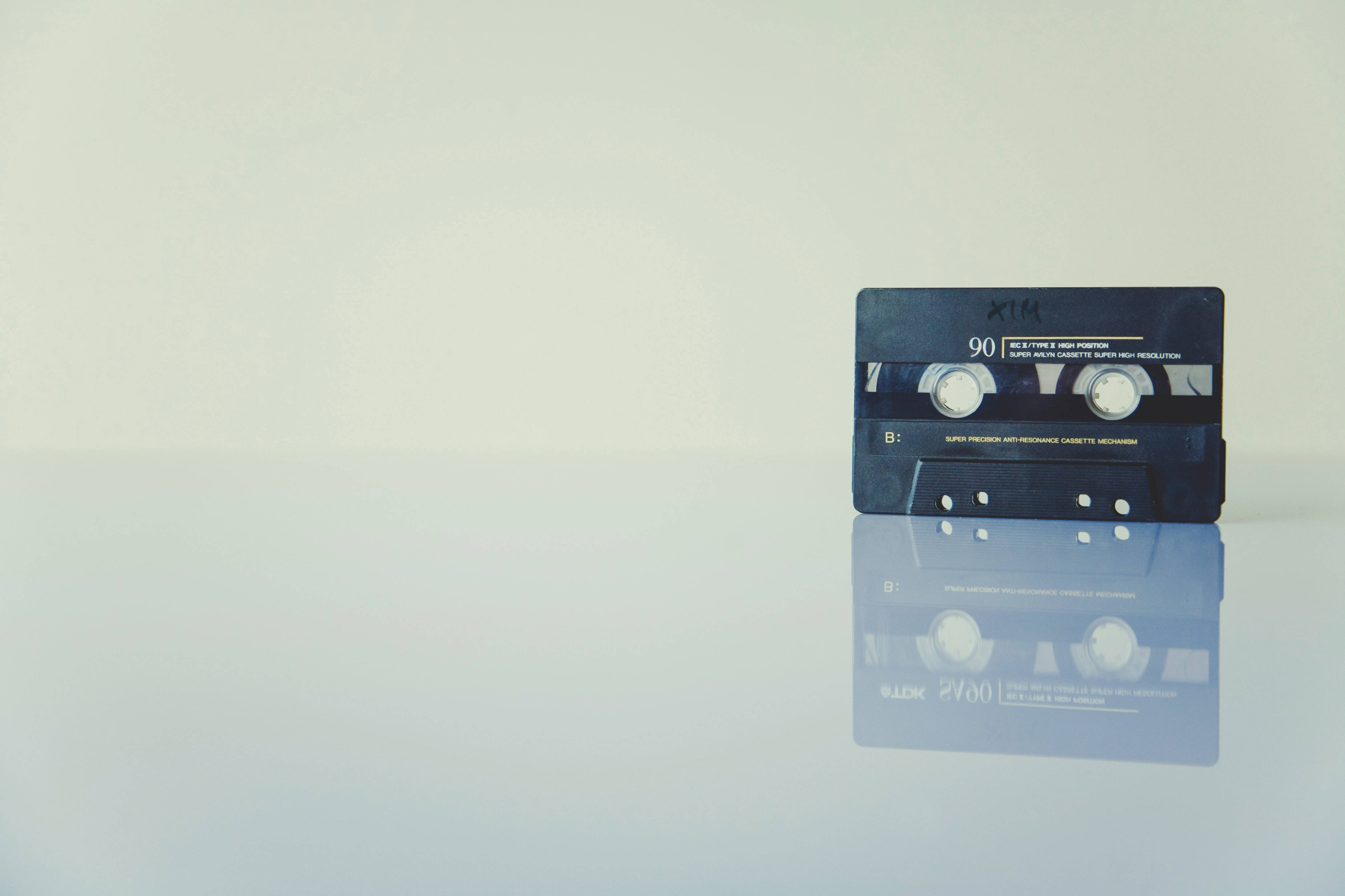 Tape Music 4K, vintage black audio cassette tape, reflective white surface, 4K Desktop Wallpaper