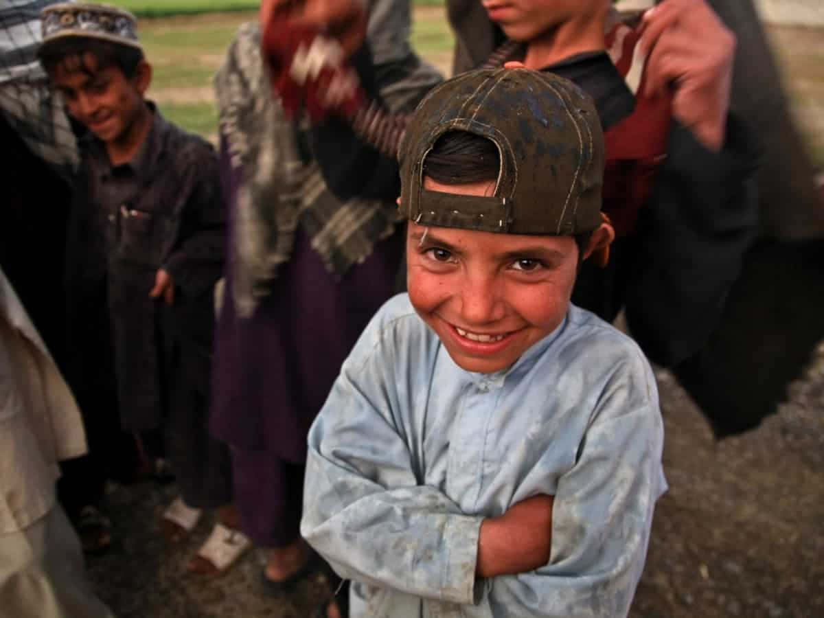 young Muslim boy, worn cap, blurred children, SD Desktop Wallpaper