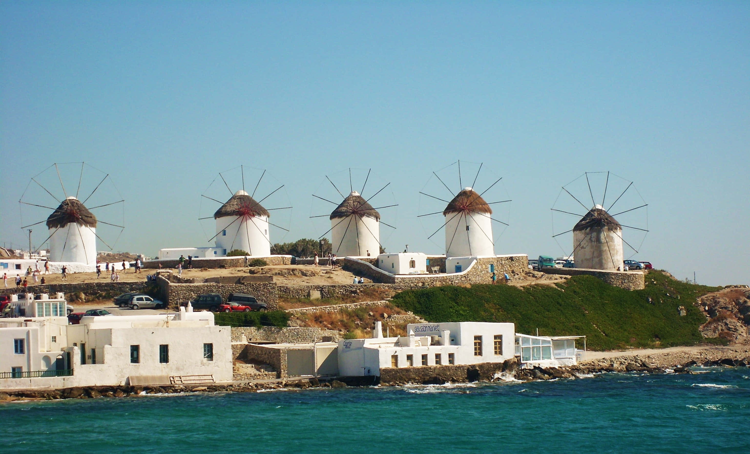 Mykonos Windmills, sunlit hill, turquoise sea, 2K Desktop Wallpaper