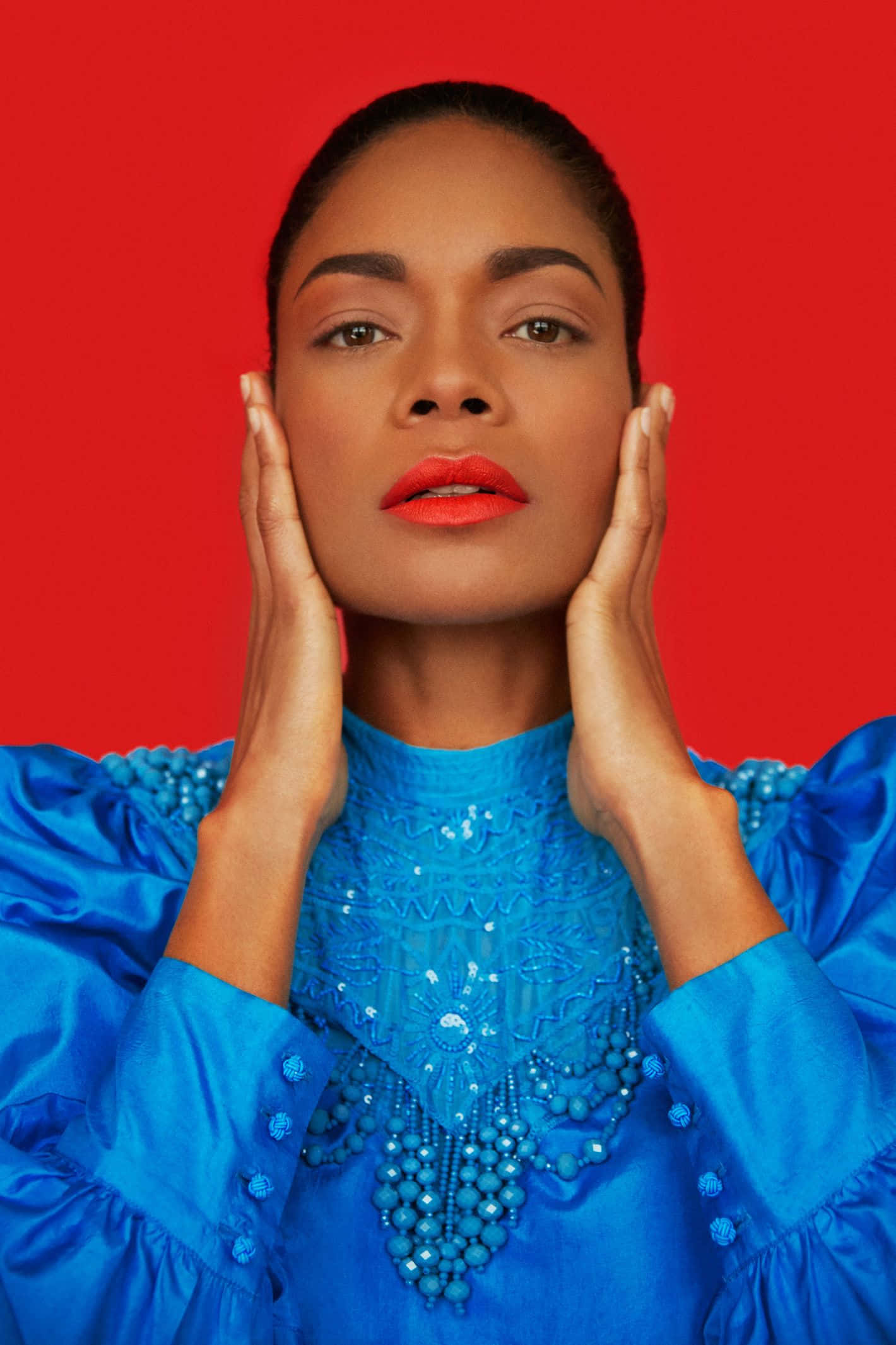 Naomie Harris, vibrant blue beaded gown, bold red background, Full HD Phone Wallpaper
