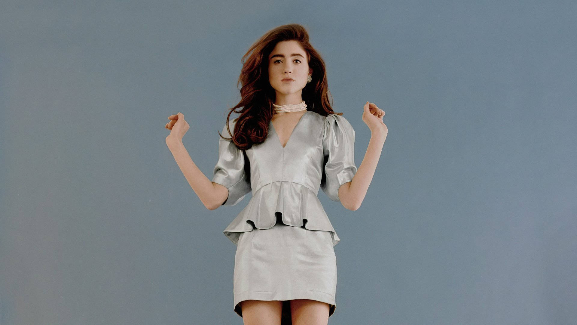 Natalia Dyer, shiny silver dress, muted blue studio backdrop, Full HD Desktop Wallpaper