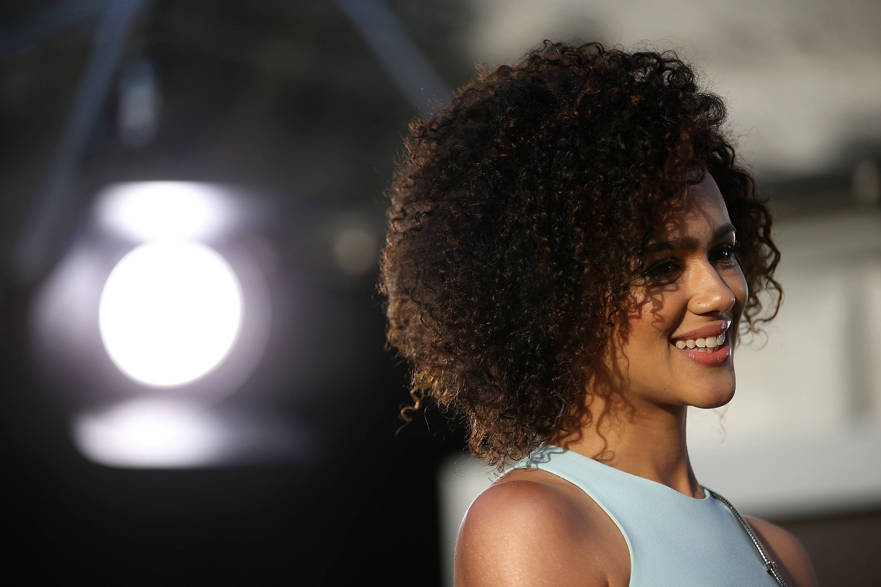 Nathalie Emmanuel, voluminous curly hair, soft daylight, 2K Desktop Wallpaper