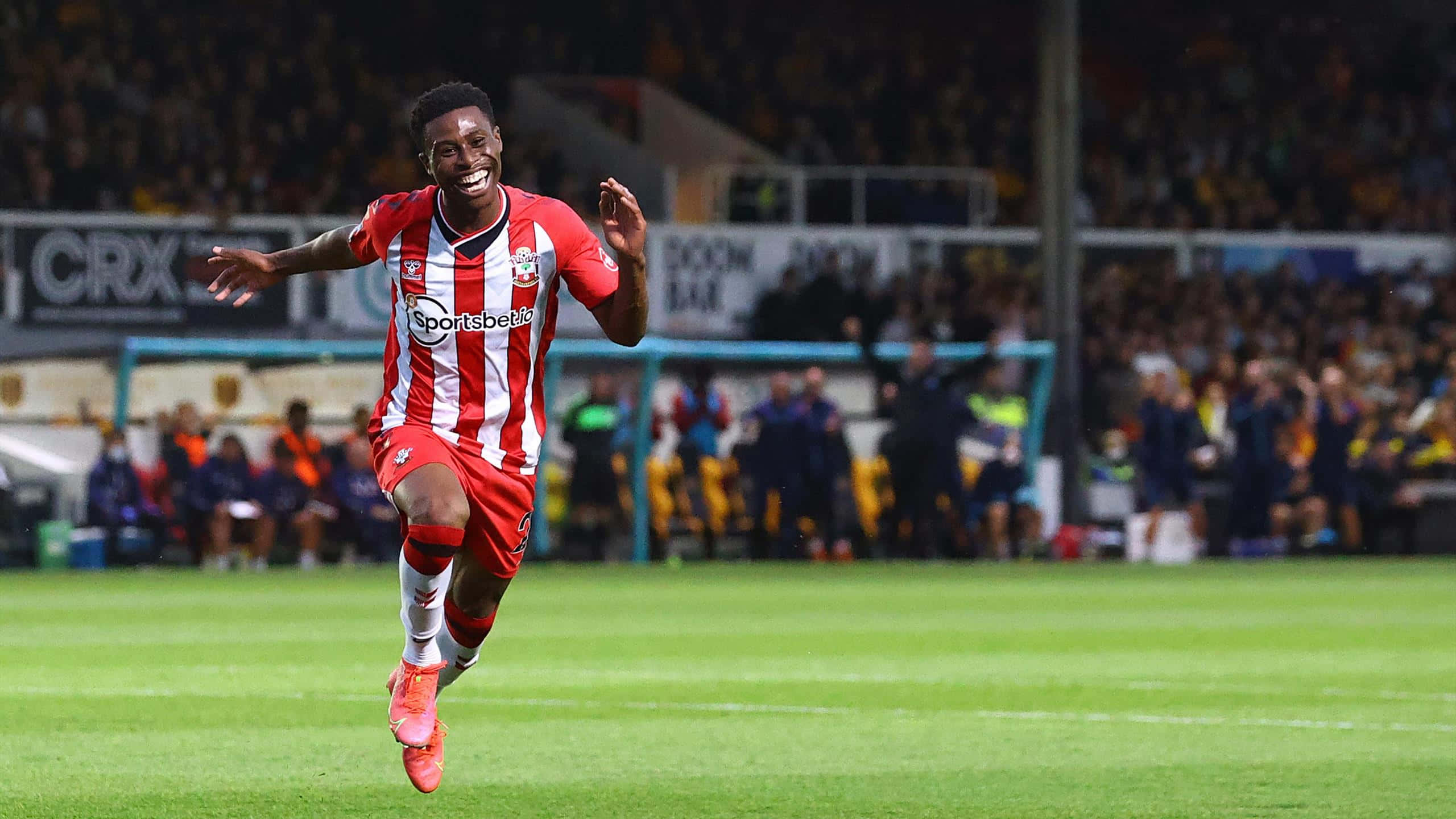 Nathan Tella, red and white stripes, vibrant green pitch, 2K Desktop Wallpaper
