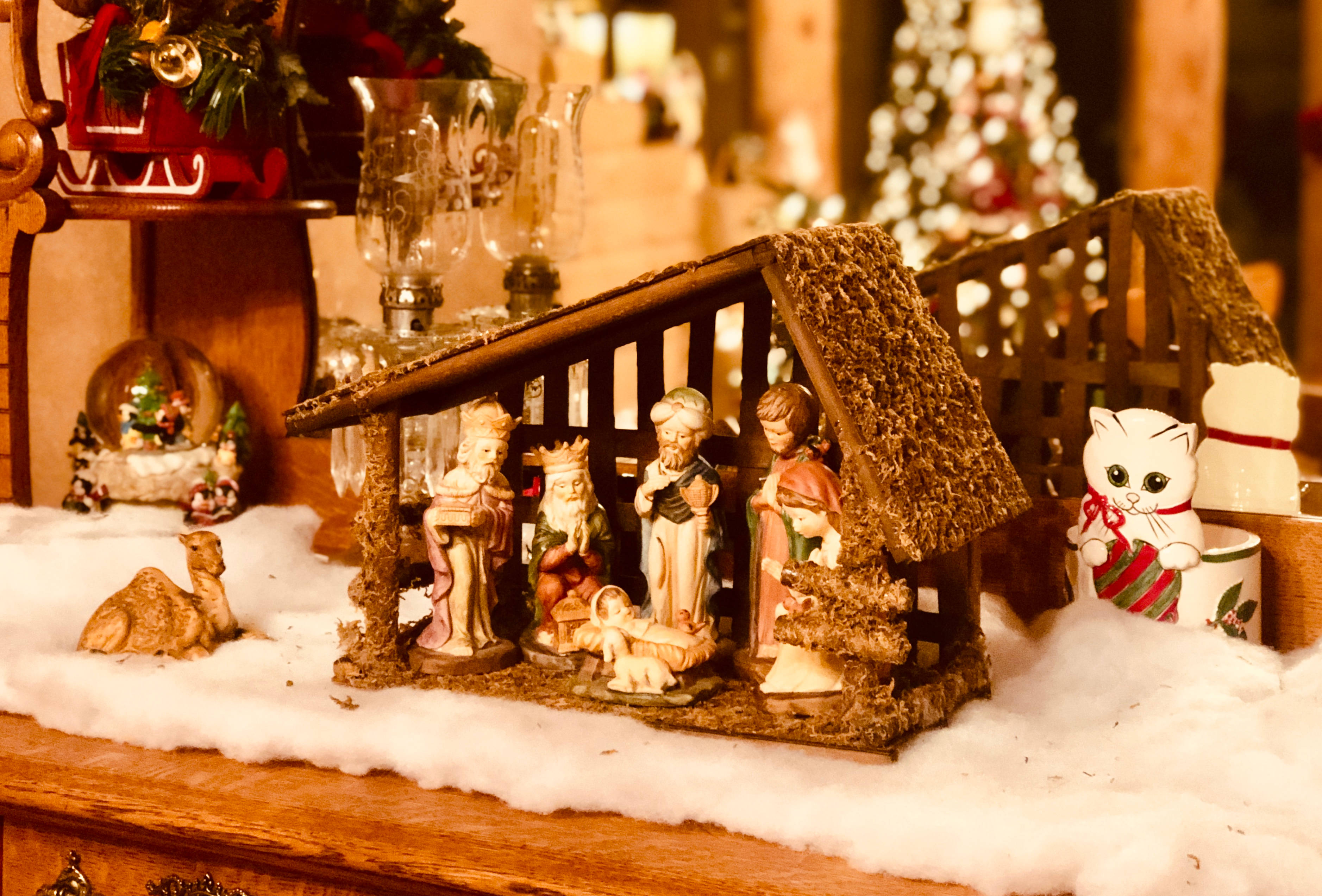 Christmas manger nativity scene figurines, faux snow, wooden shelf, 2K Desktop Wallpaper