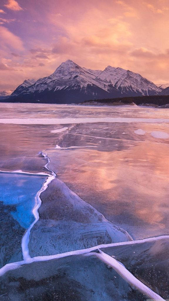 frozen lake, vibrant pink and orange sunset, snow-capped mountains, SD Phone Wallpaper