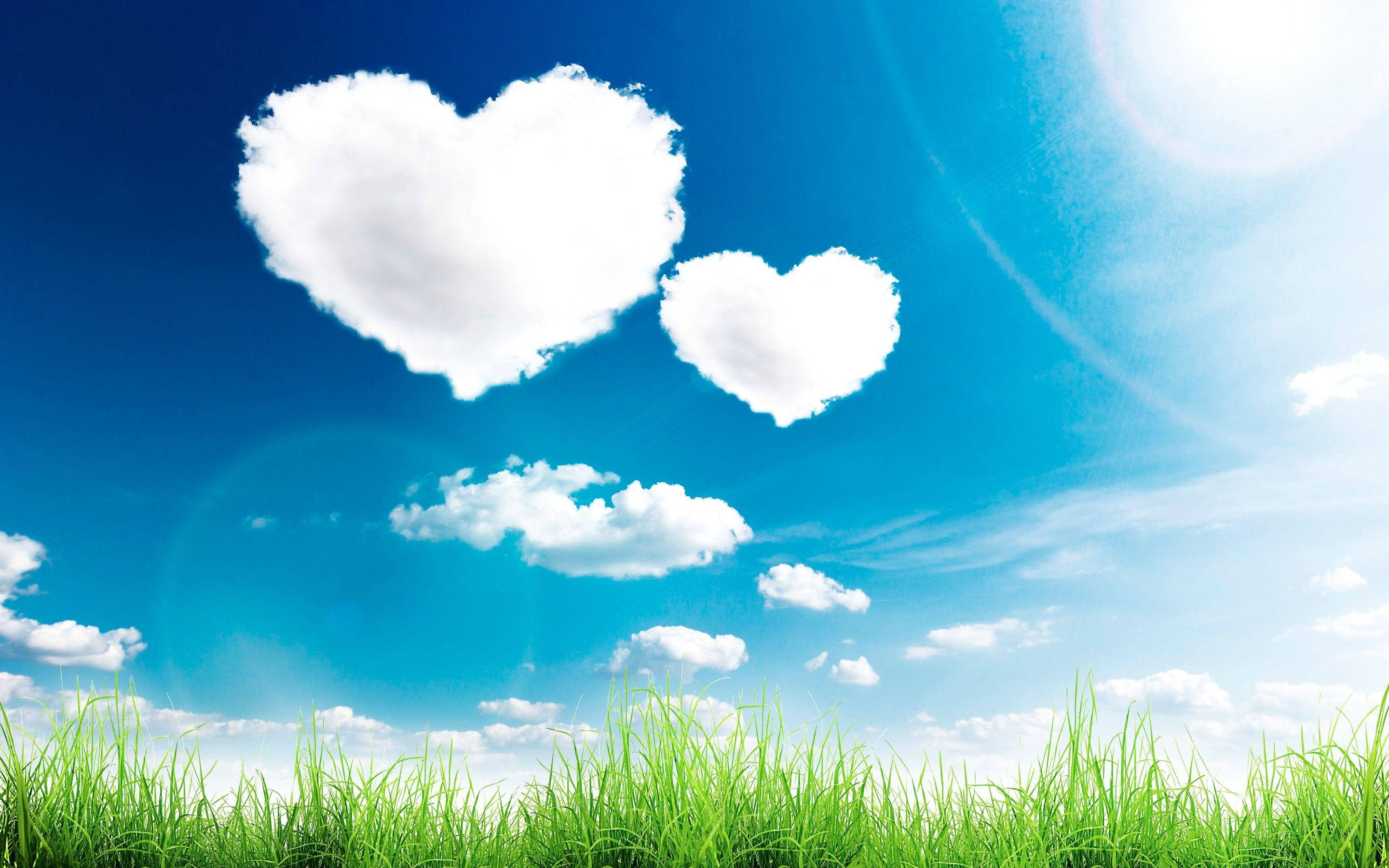 Nature Love, two heart-shaped clouds, vibrant green grass, 2K Desktop Wallpaper