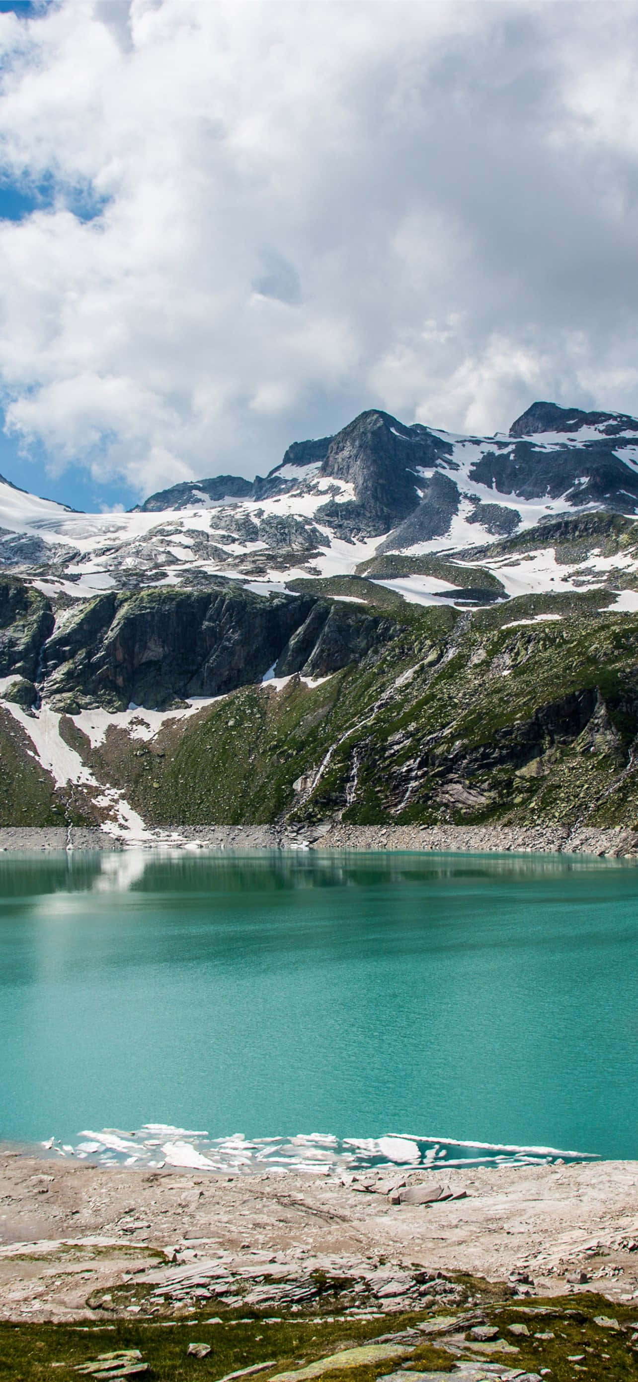 turquoise mountain lake, snow-capped peaks, partly cloudy sky, 2K Phone Wallpaper