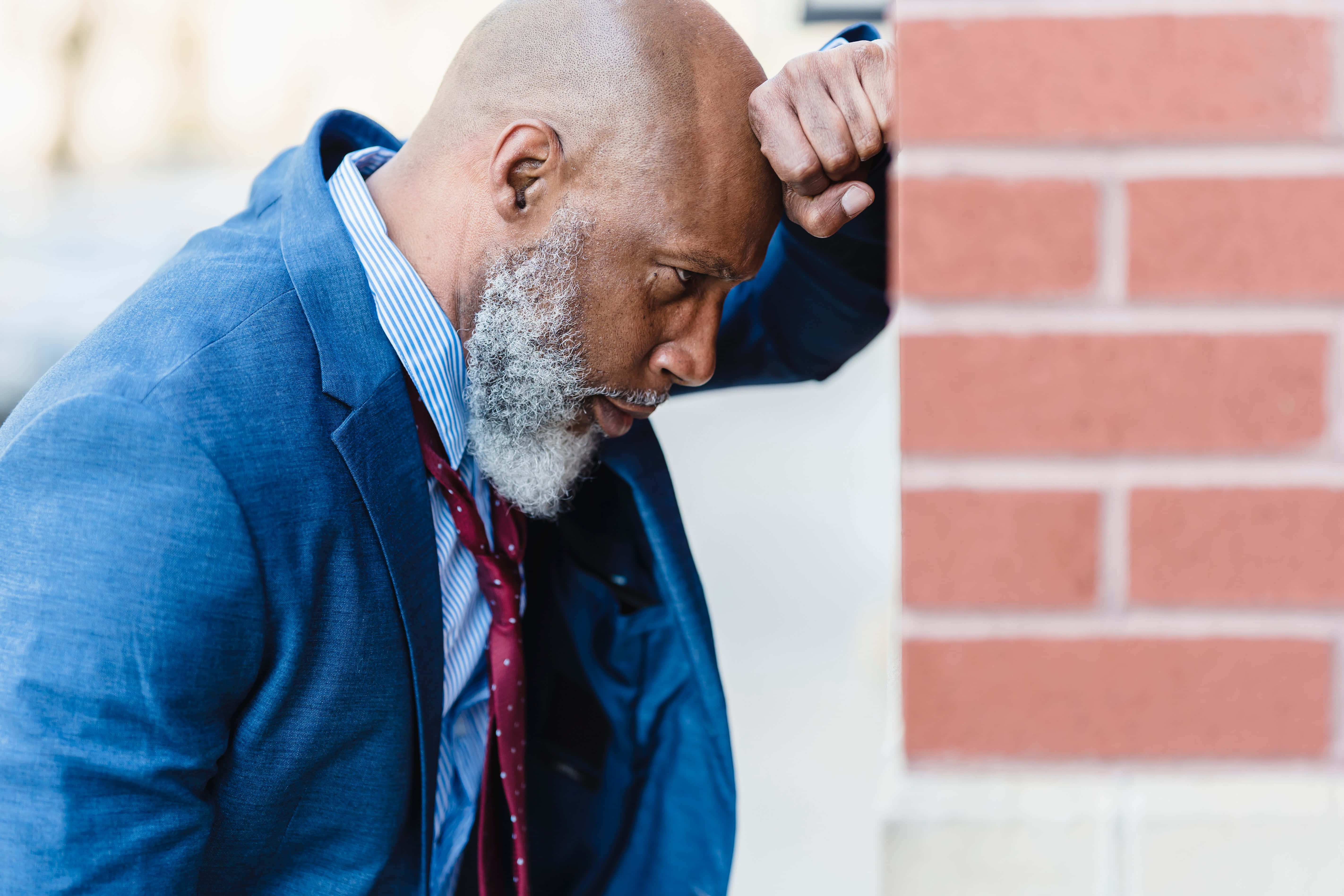 navy blue suit, red brick wall, weary man, 5K Desktop Wallpaper