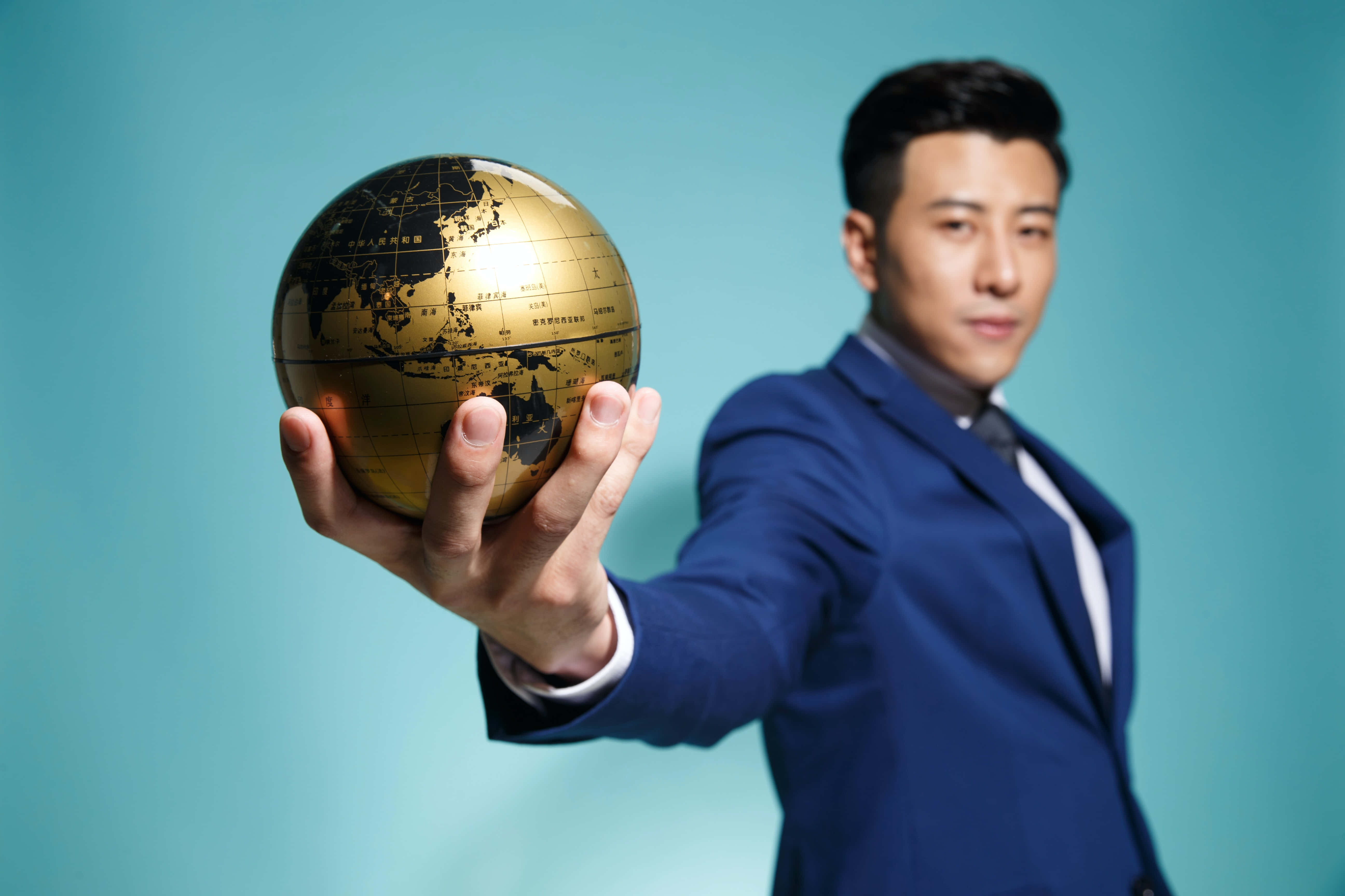 navy blue suit, golden globe, teal background, 5K Desktop Wallpaper