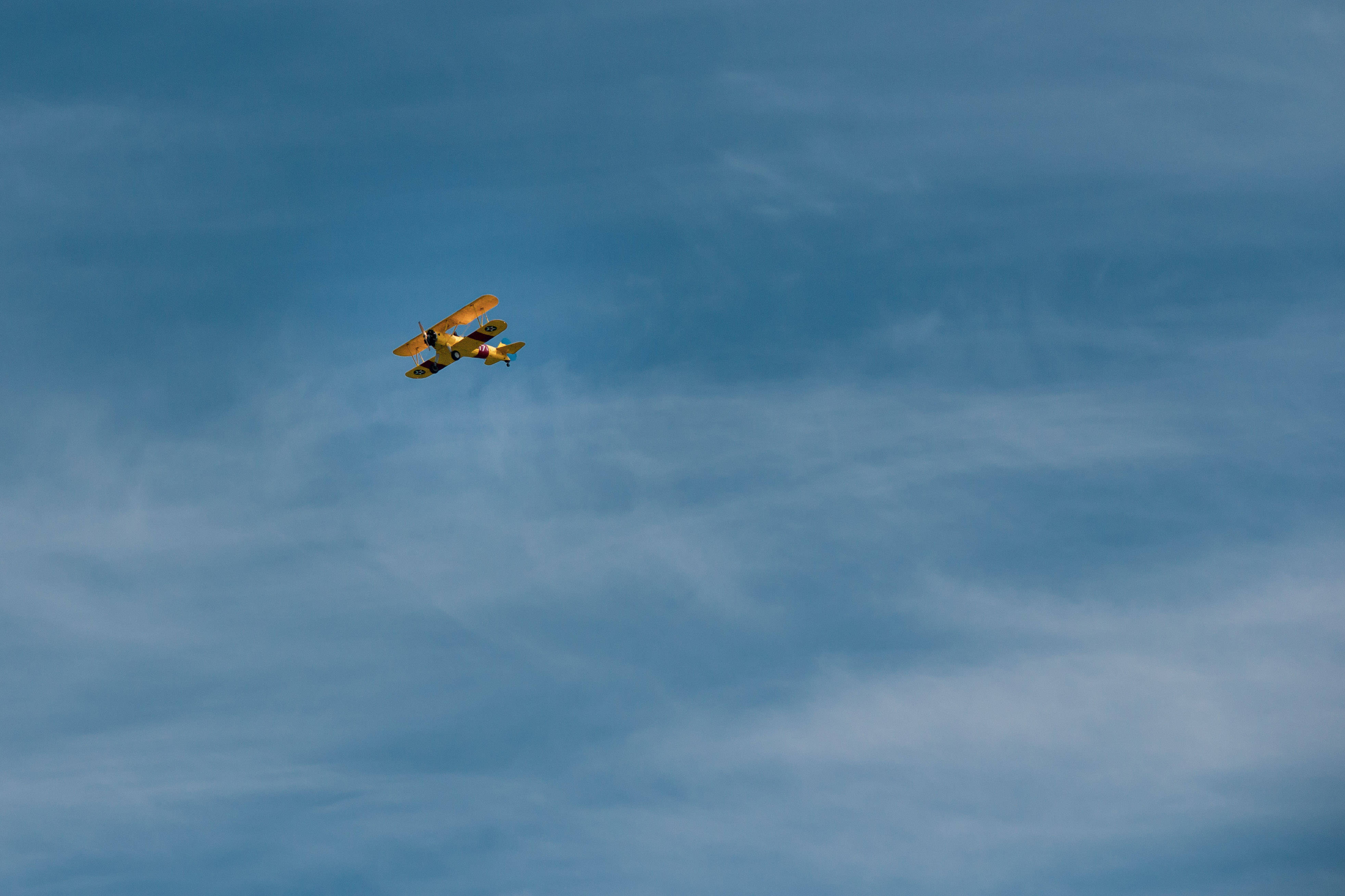 vintage yellow biplane, vast blue sky, wispy white clouds, 4K Desktop Wallpaper