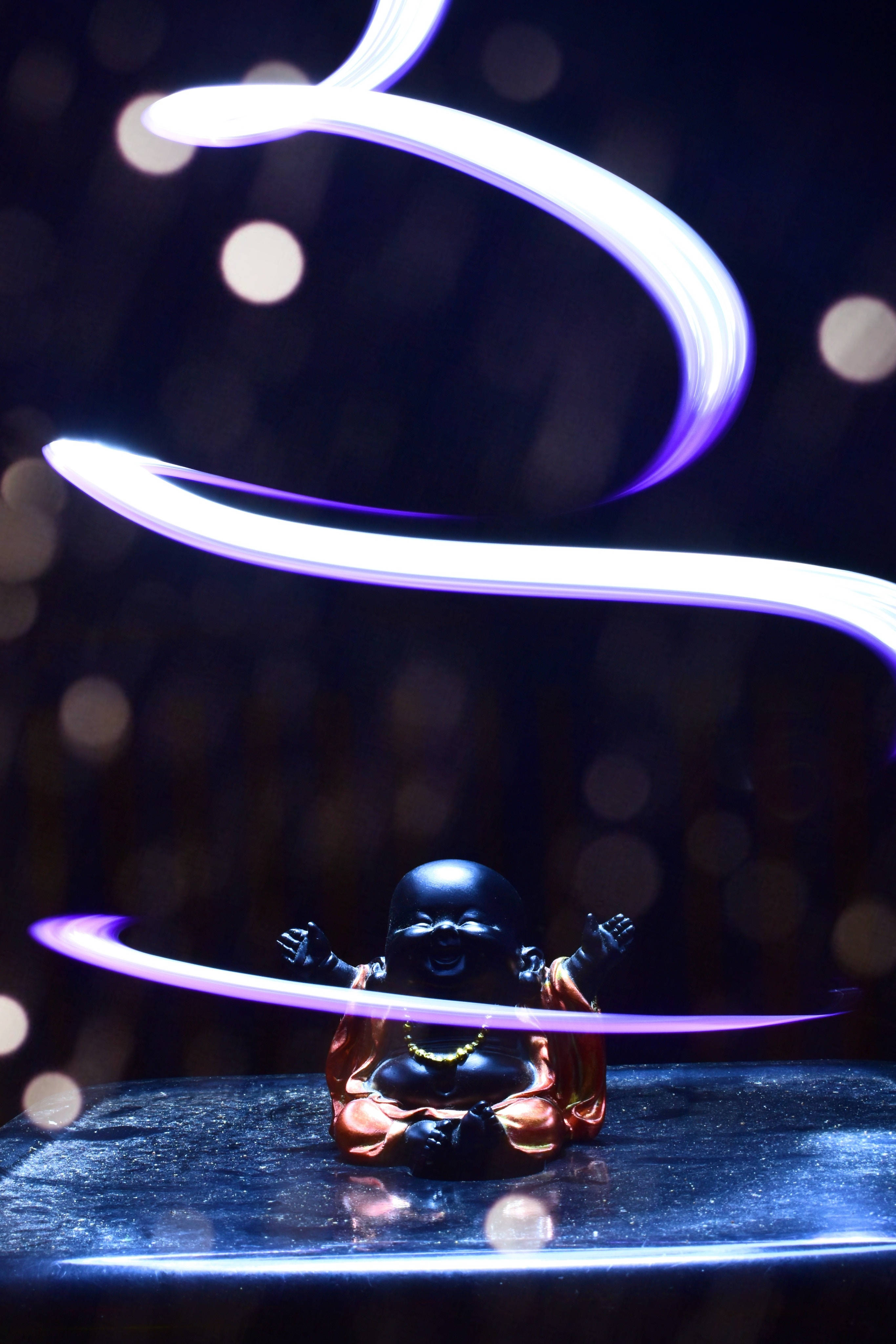 Baby Buddha Figurine, glowing purple light trails, dark bokeh background, 4K Phone Wallpaper