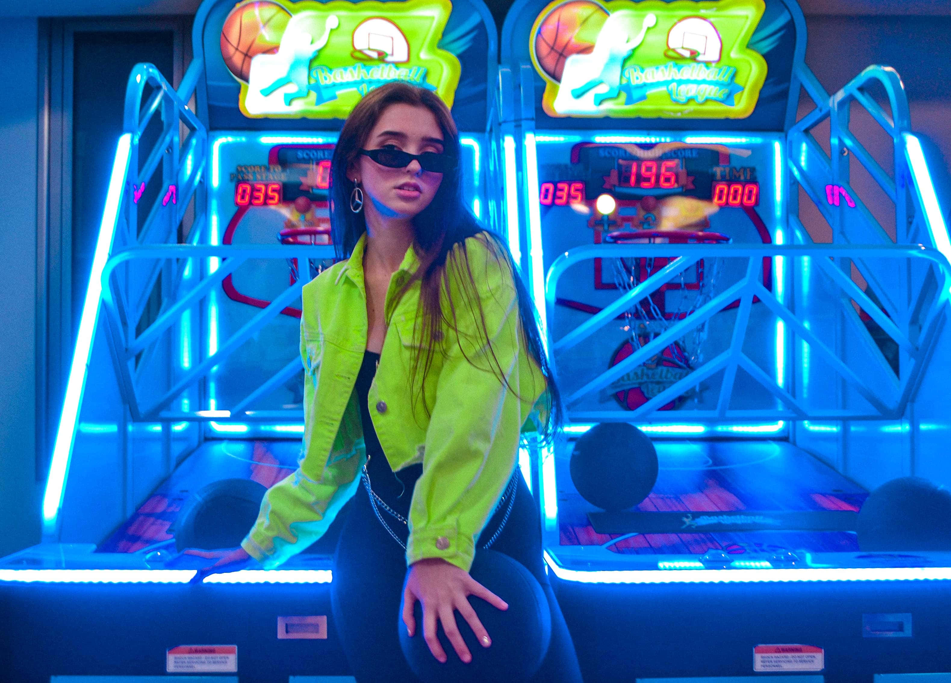 neon yellow jacket, glowing blue basketball arcade machines, woman, 2K Desktop Wallpaper