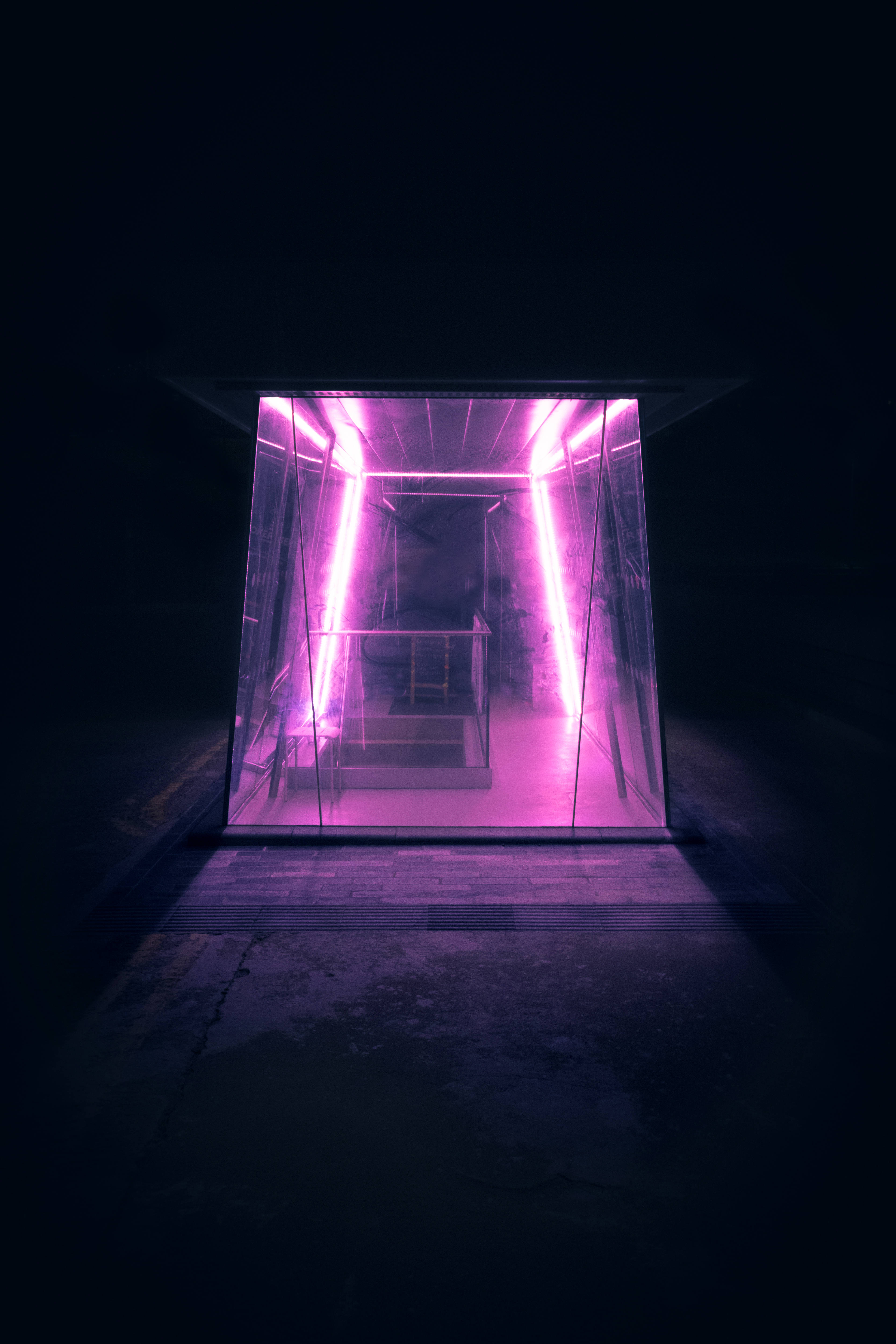 glowing purple neon-lit glass elevator shaft, dark concrete space, vibrant light, 5K Phone Wallpaper
