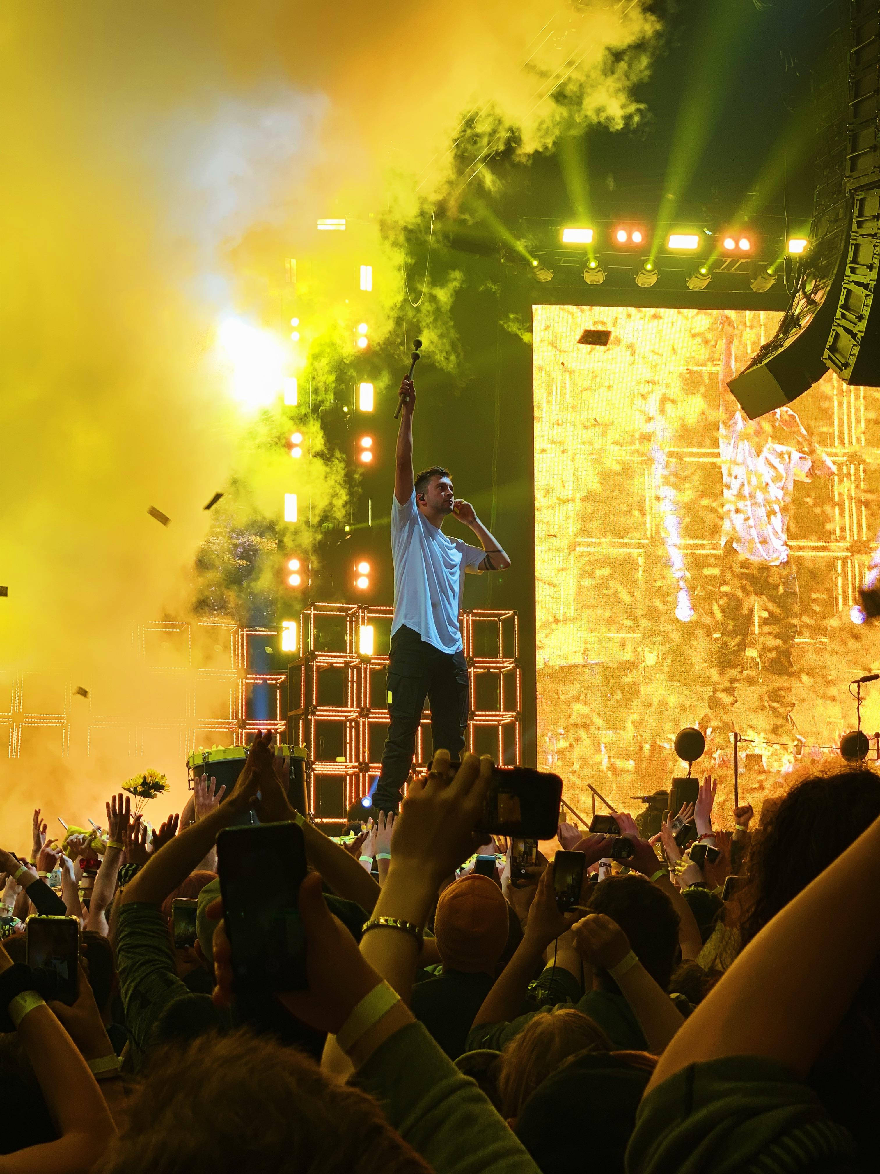 neon yellow stage, white shirt, microphone, 4K Phone Wallpaper