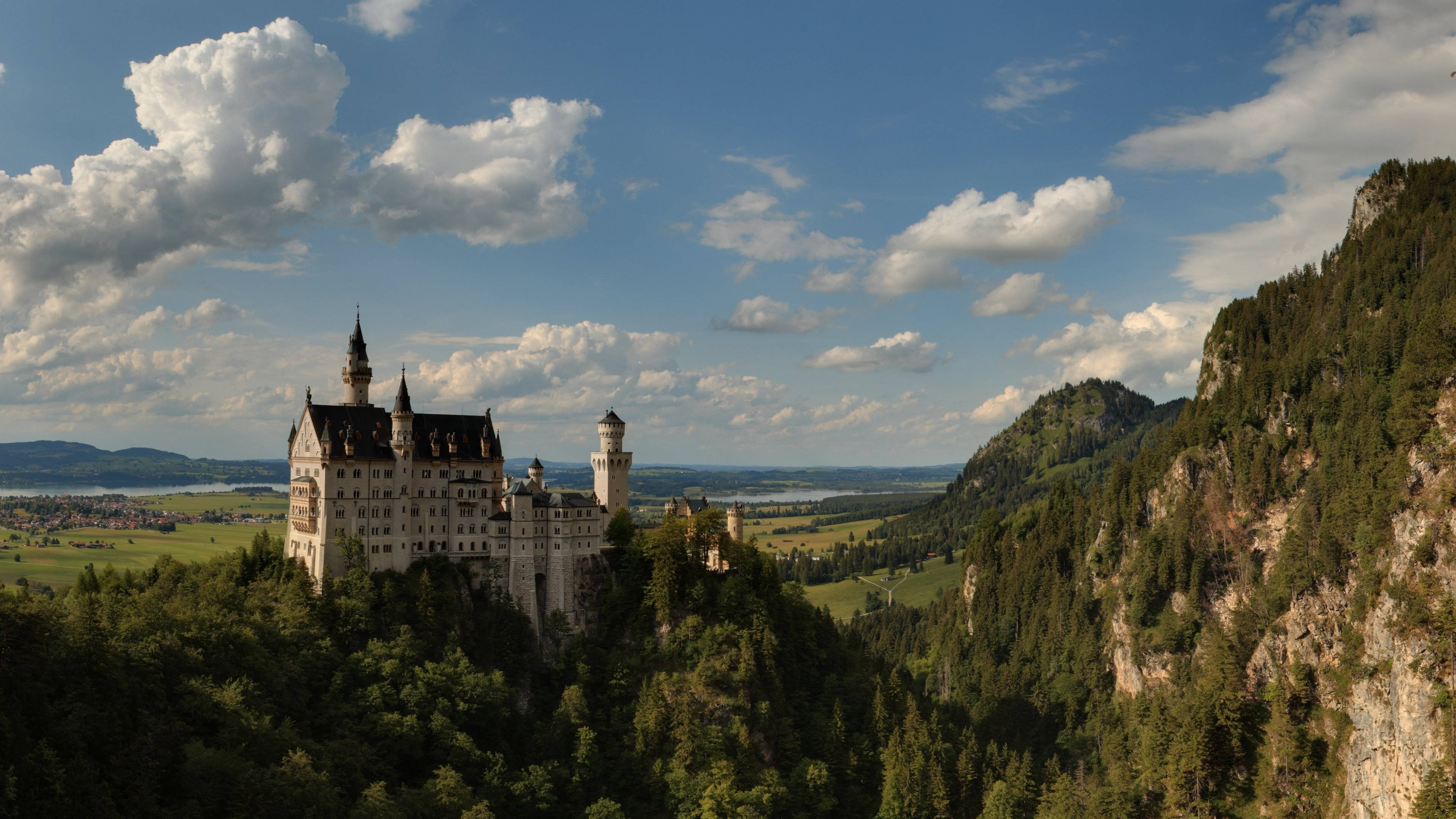 Neuschwanstein Castle, rocky cliffs, lush green hillside, 4K Desktop Wallpaper