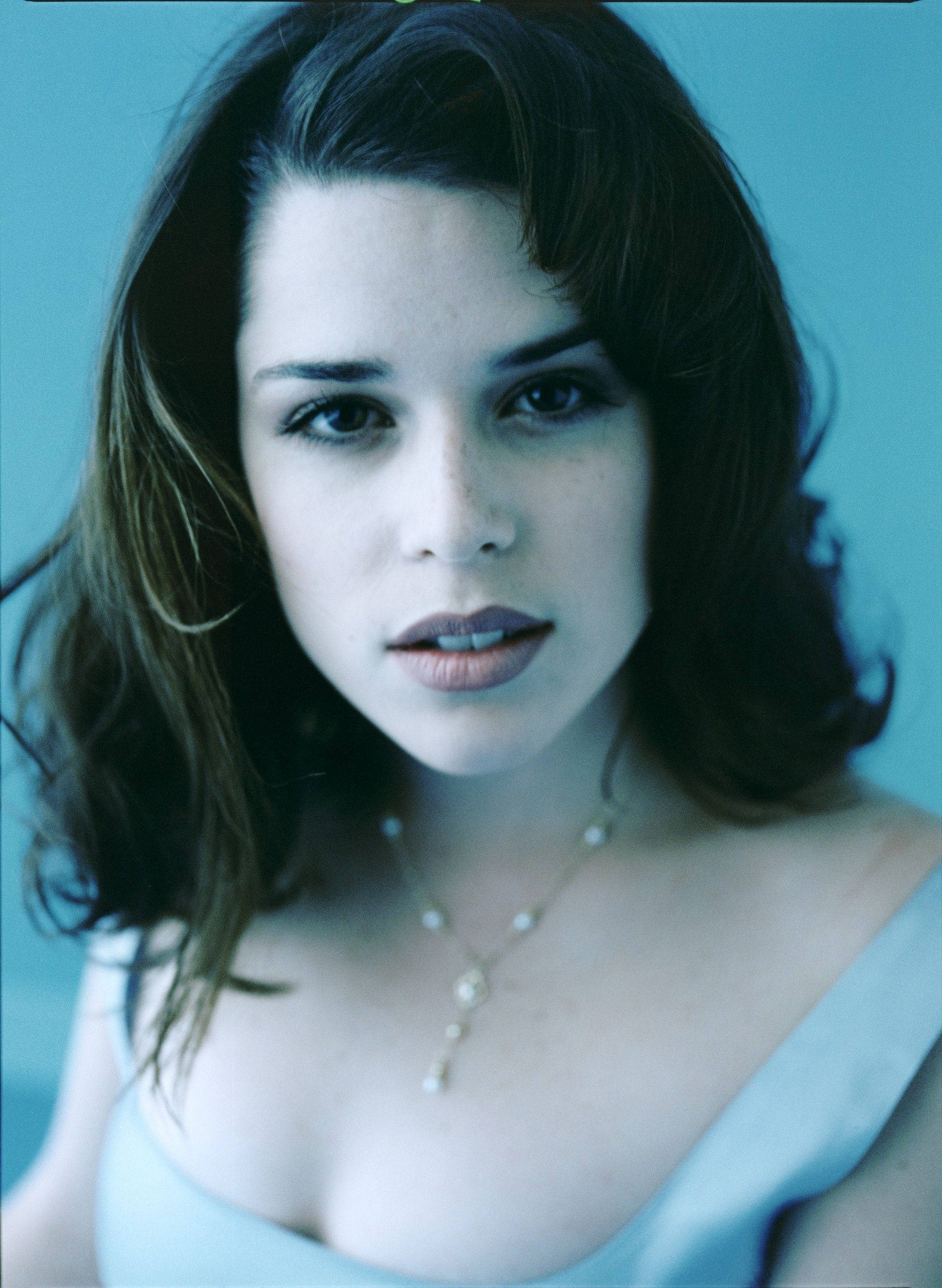 Neve Campbell, blue top, dark wavy hair, 2K Phone Wallpaper