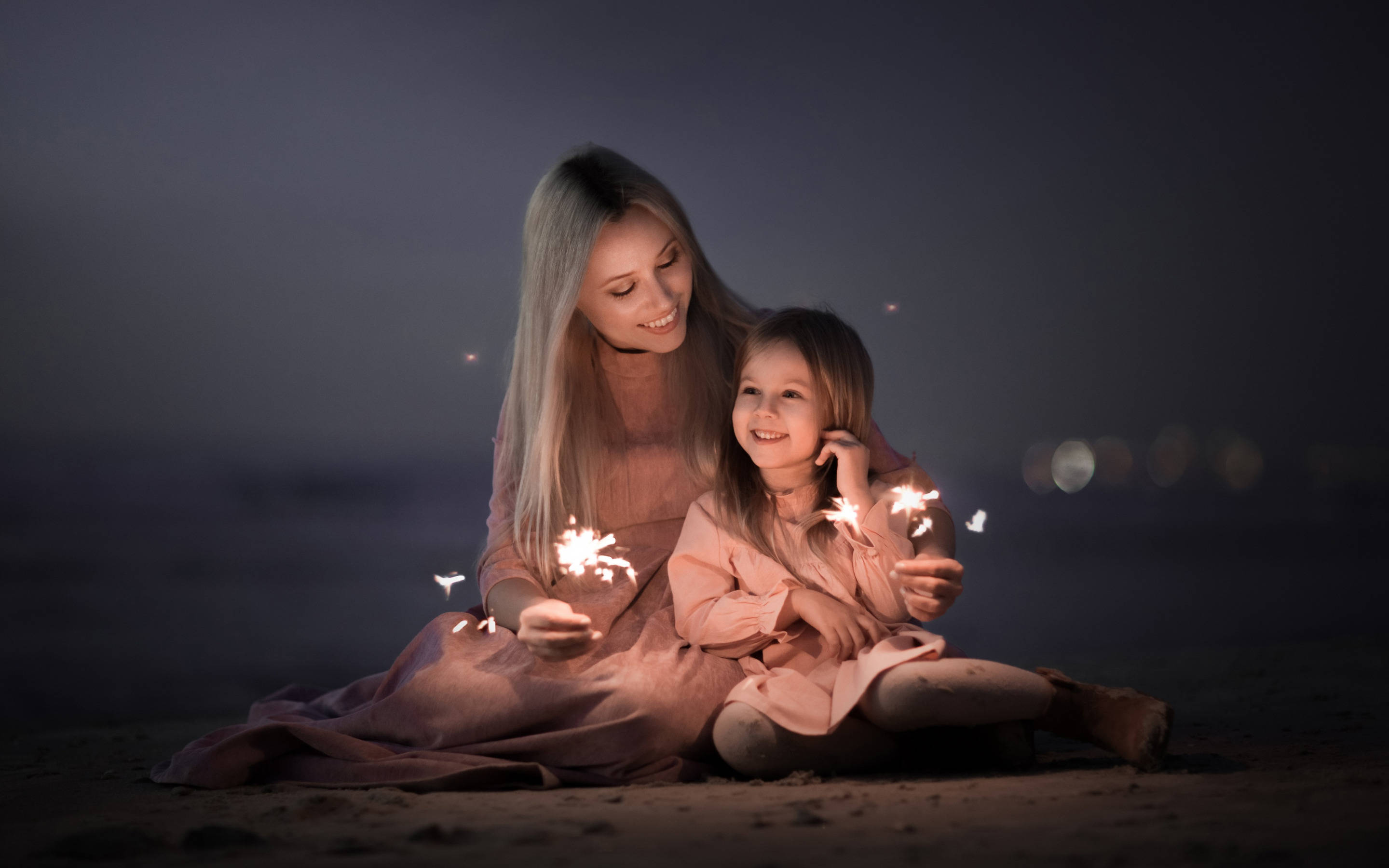 mother and daughter, beach at night, sparklers glowing warmly, 2K Desktop Wallpaper