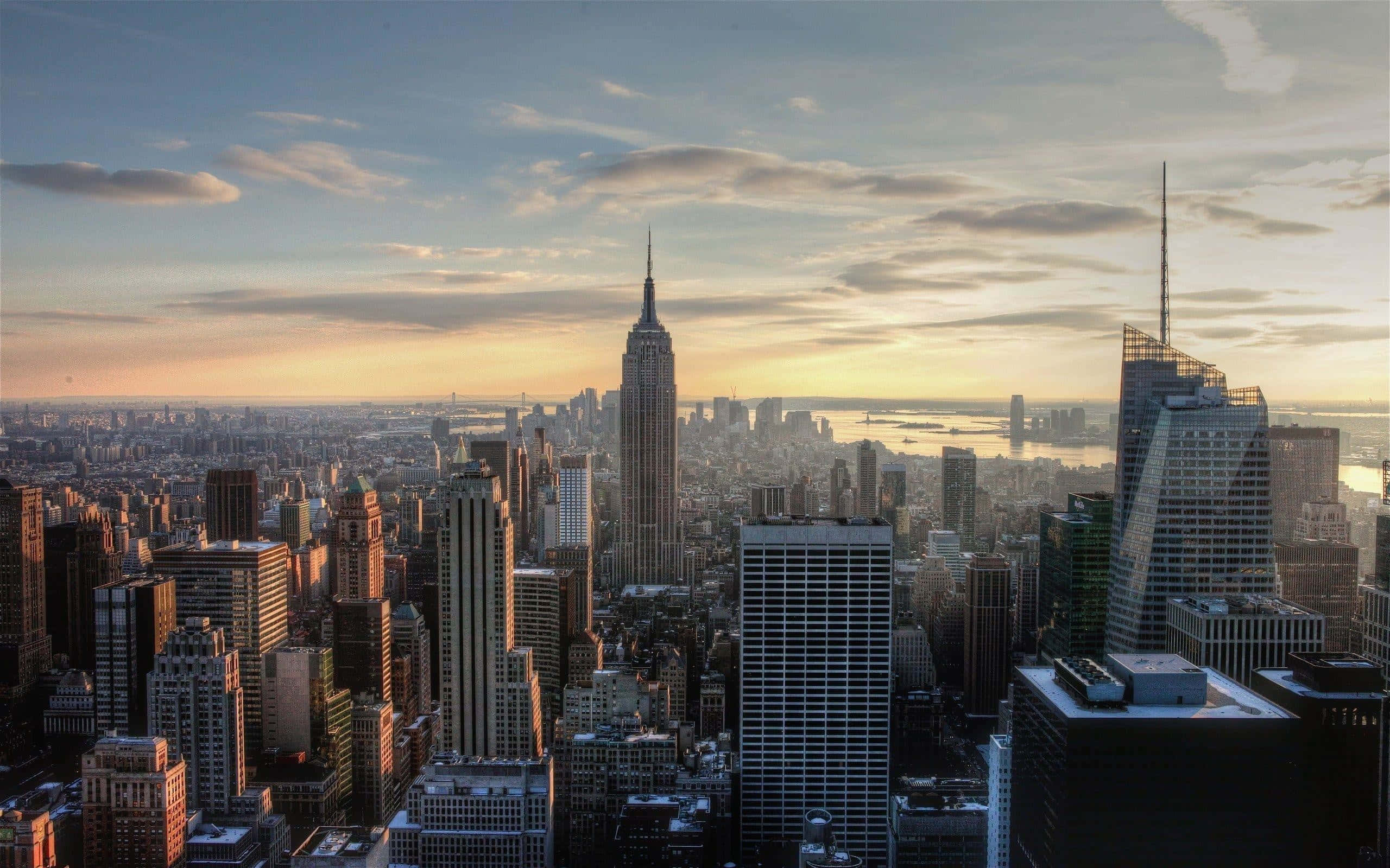 New York City skyline, Golden hour sunlight, towering skyscrapers, 2K Desktop Wallpaper