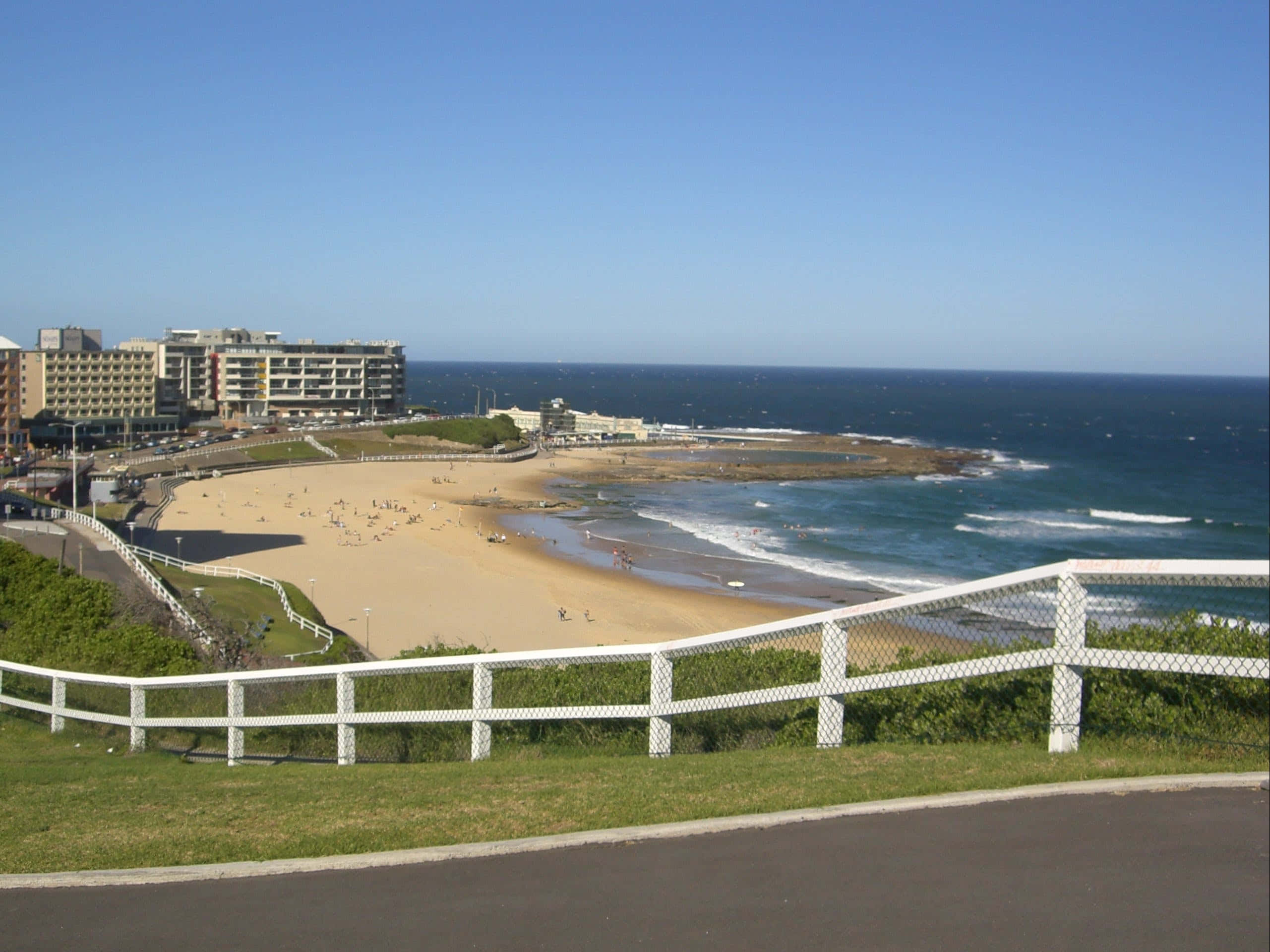 Newcastle Australia, sunny coastal beach scene, turquoise waves, 2K Desktop Wallpaper
