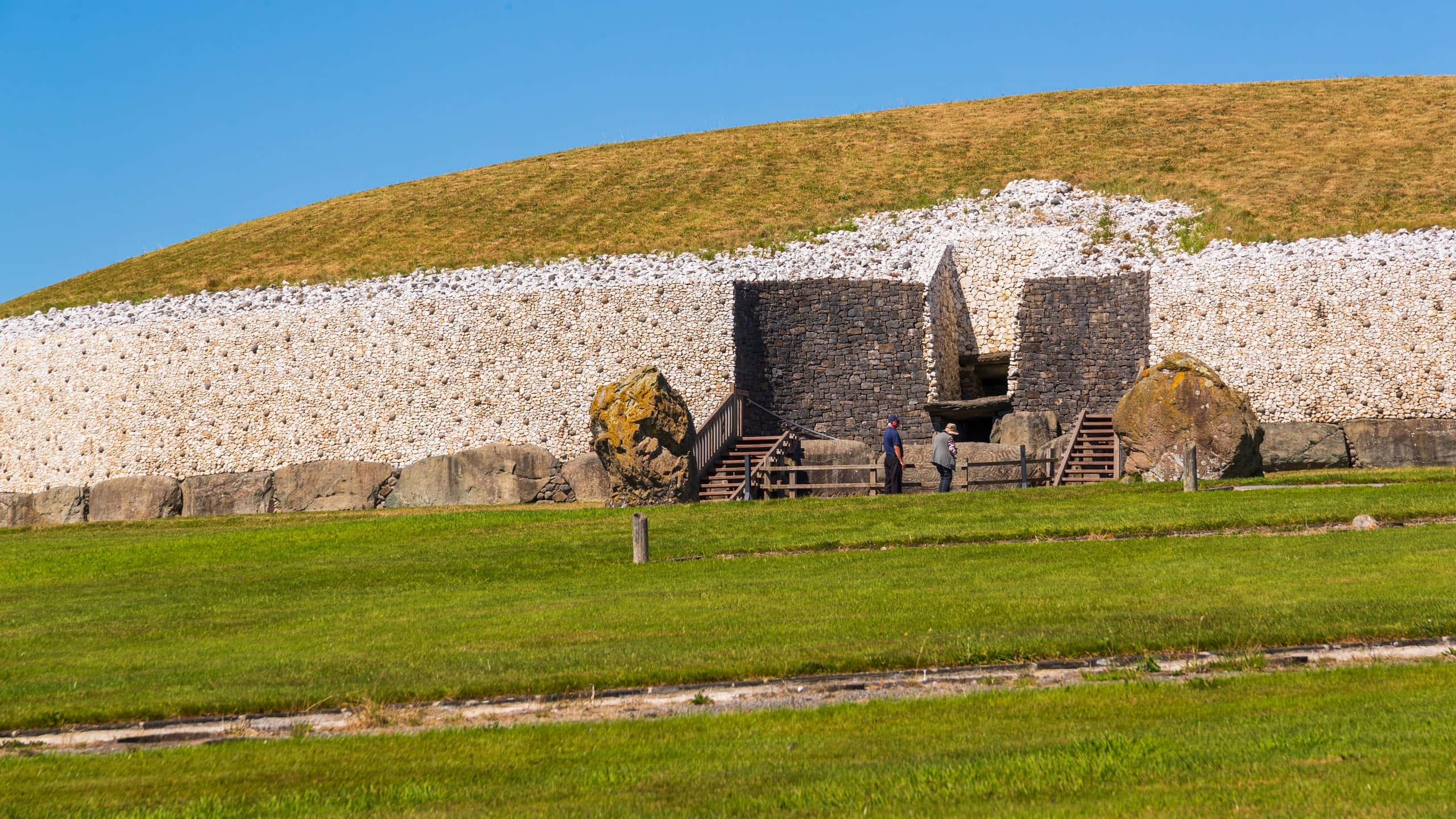 Newgrange, grass-covered hilltop, ancient stone burial mound, 2K Desktop Wallpaper