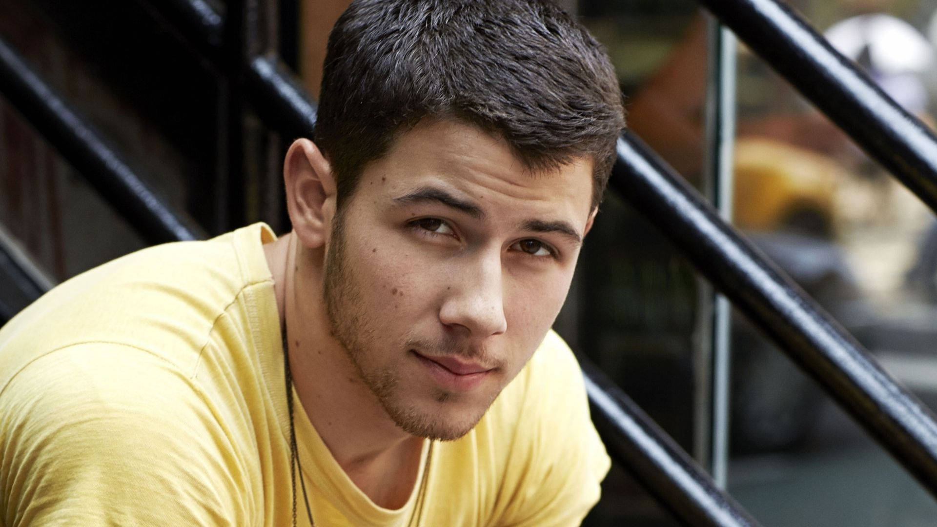 Nick Jonas, yellow t-shirt, black railings, Full HD Desktop Wallpaper