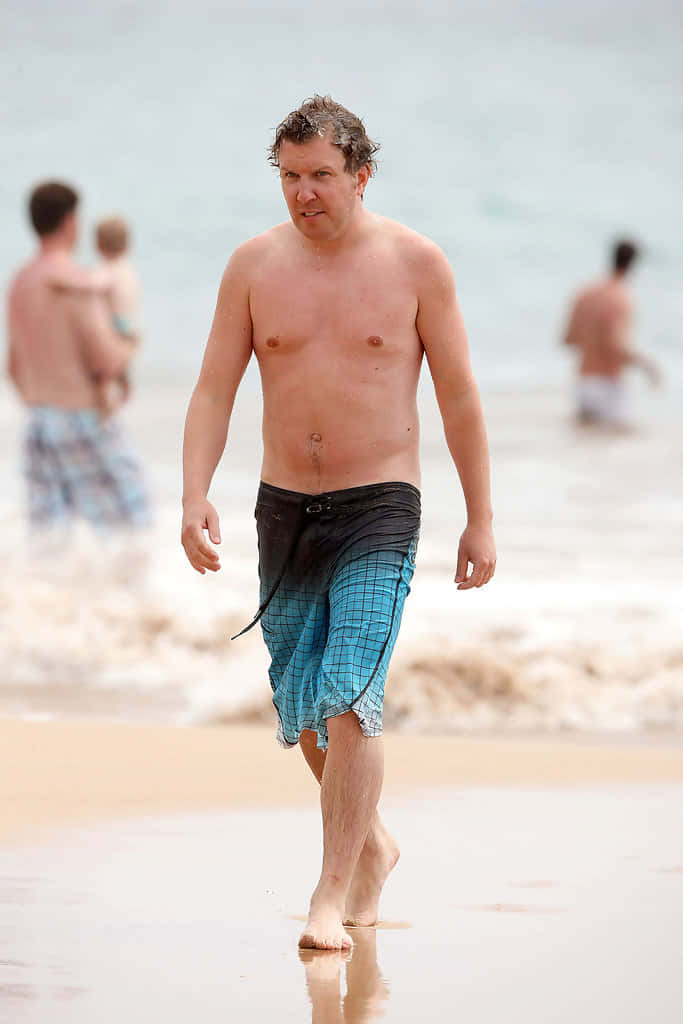 Nick Swardson, blue checkered swim trunks, wet sandy beach, SD Phone Wallpaper