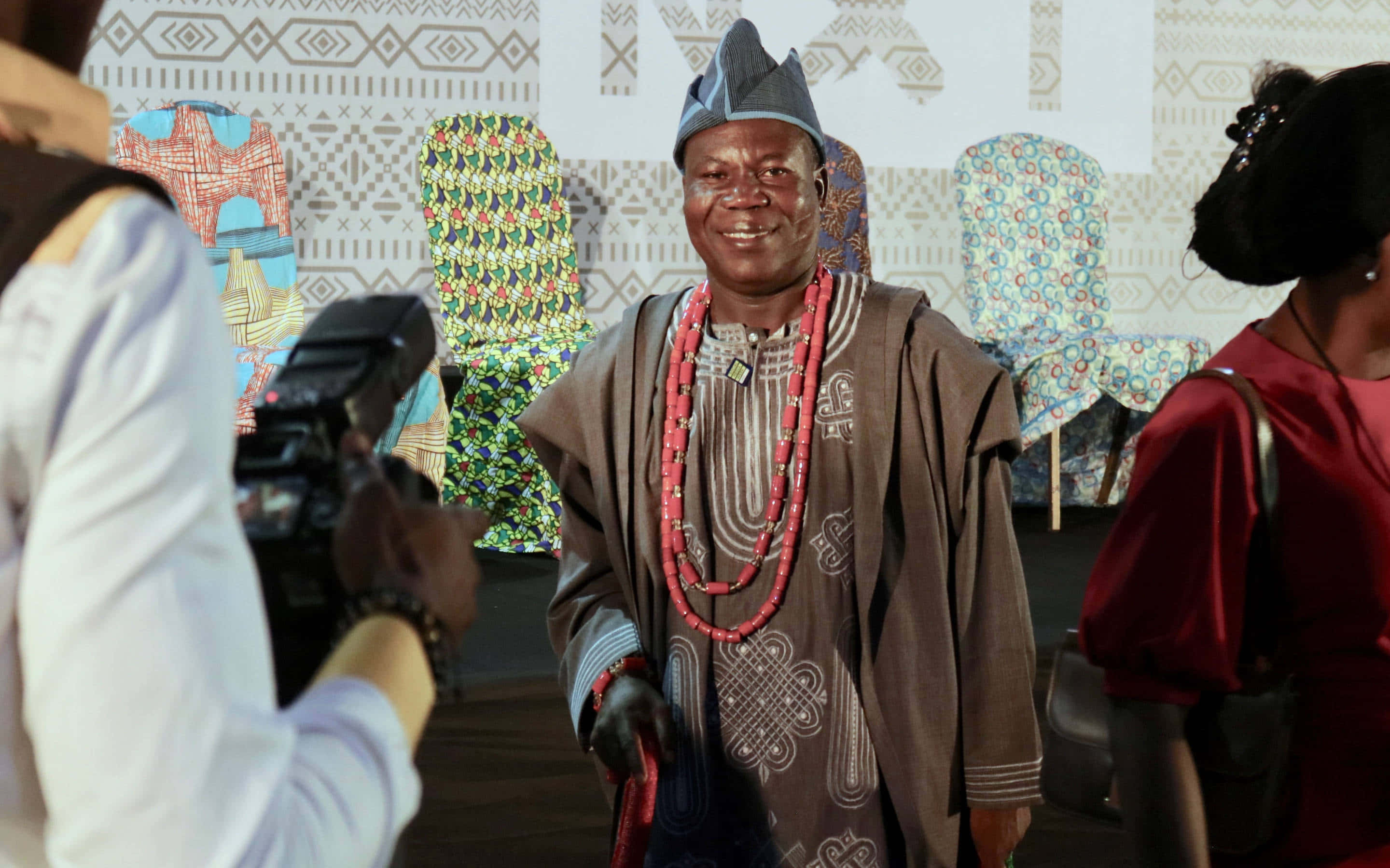smiling Nigerian Man, traditional Nigerian attire, red beaded necklace, 2K Desktop Wallpaper