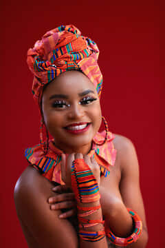 Nigerian Woman, vibrant orange patterned headwrap, matching arm cuffs, SD Phone Wallpaper