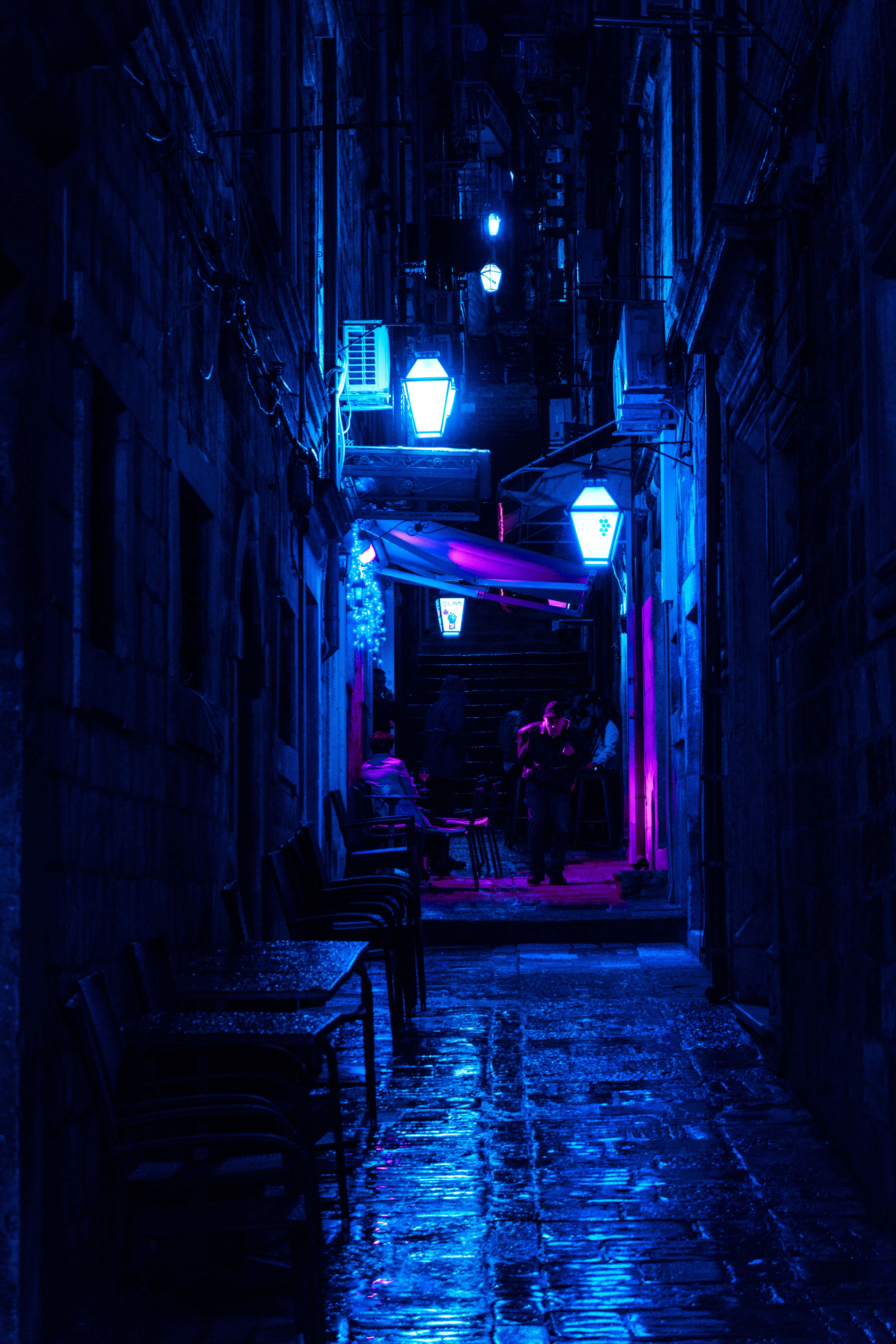 electric blue neon lights, cobblestones, silhouetted figures, 5K Phone Wallpaper