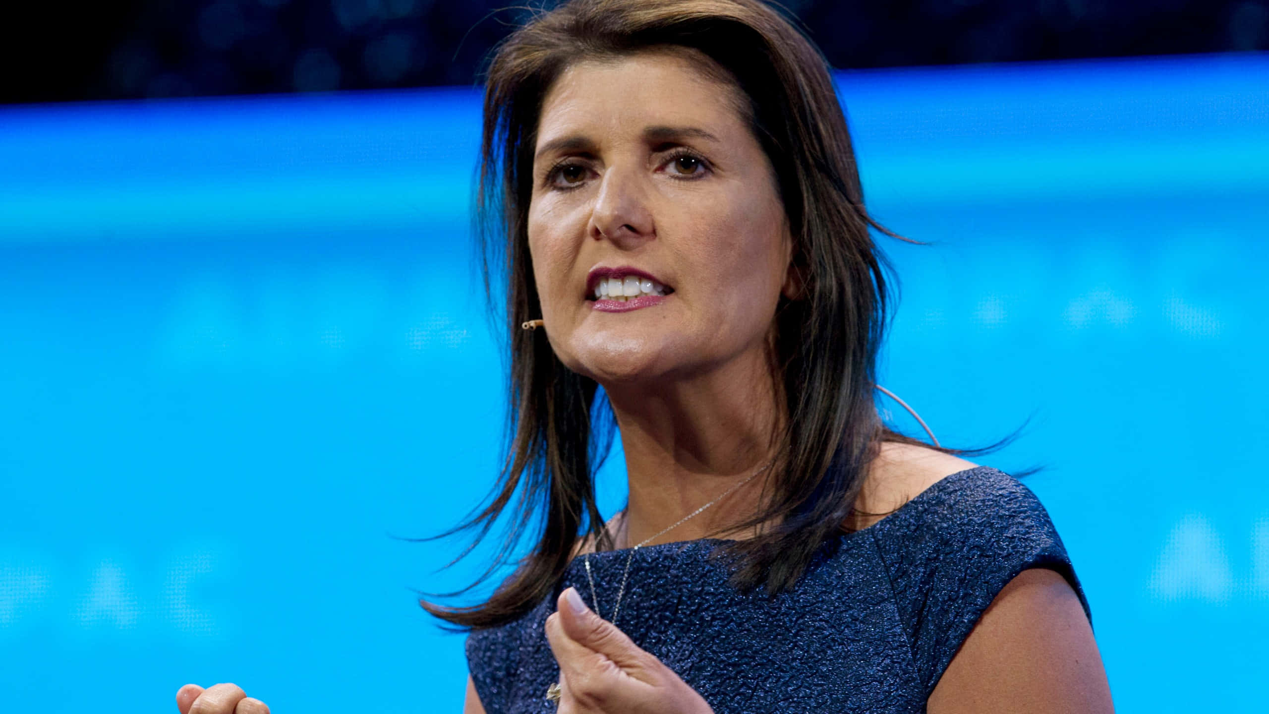 Nikki Haley, blue top, vibrant blue backdrop, 2K Desktop Wallpaper
