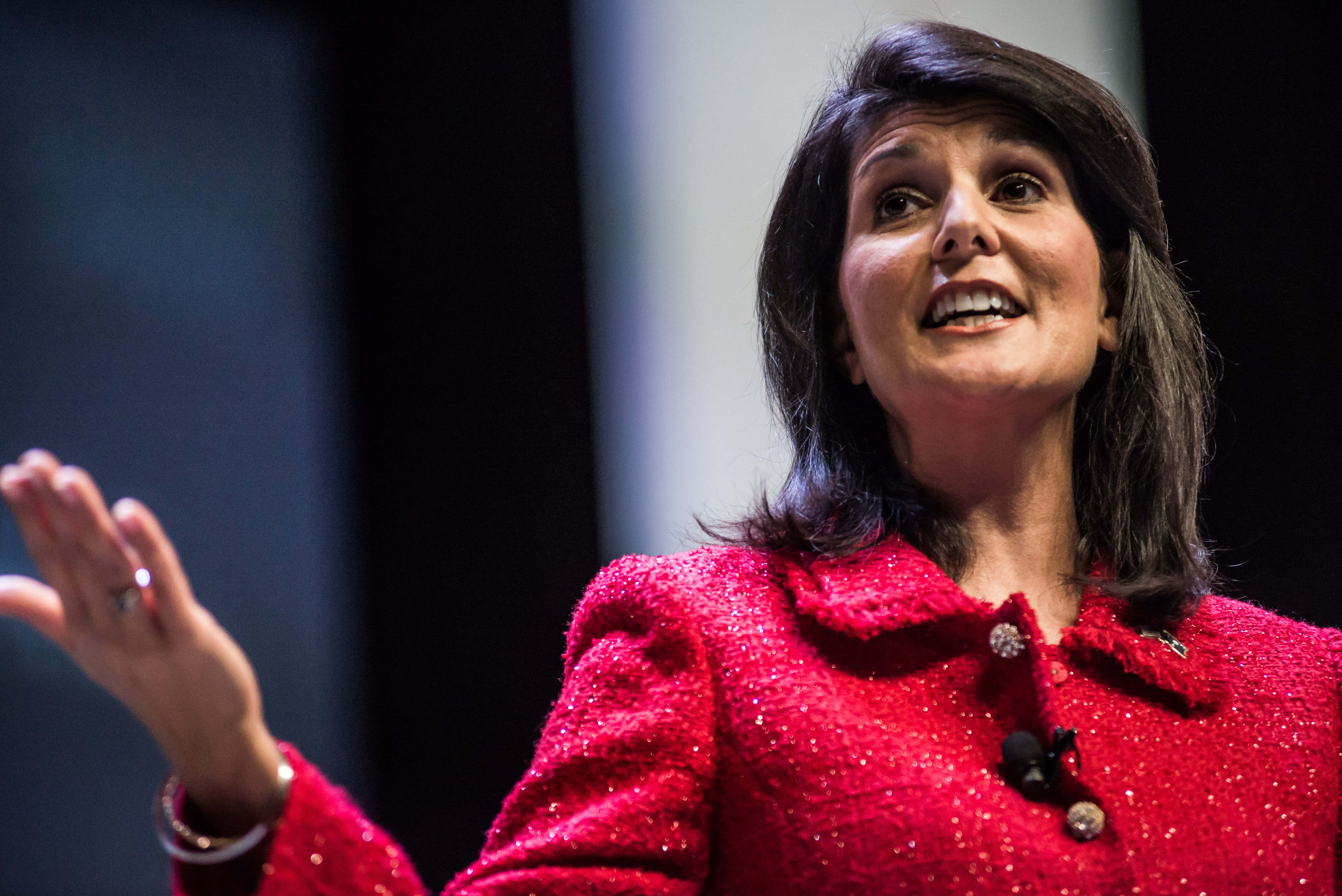Nikki Haley, sparkling red jacket, dimly lit stage, 5K Desktop Wallpaper