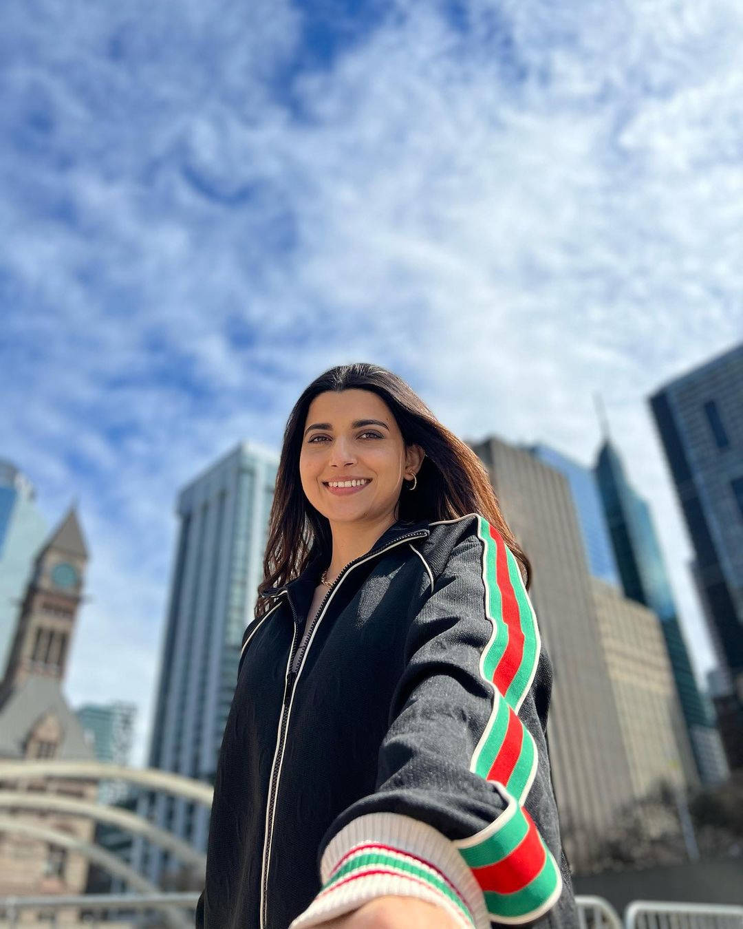 Nimrat Khaira, black jacket with red green stripes, modern skyscrapers, HD Phone Wallpaper
