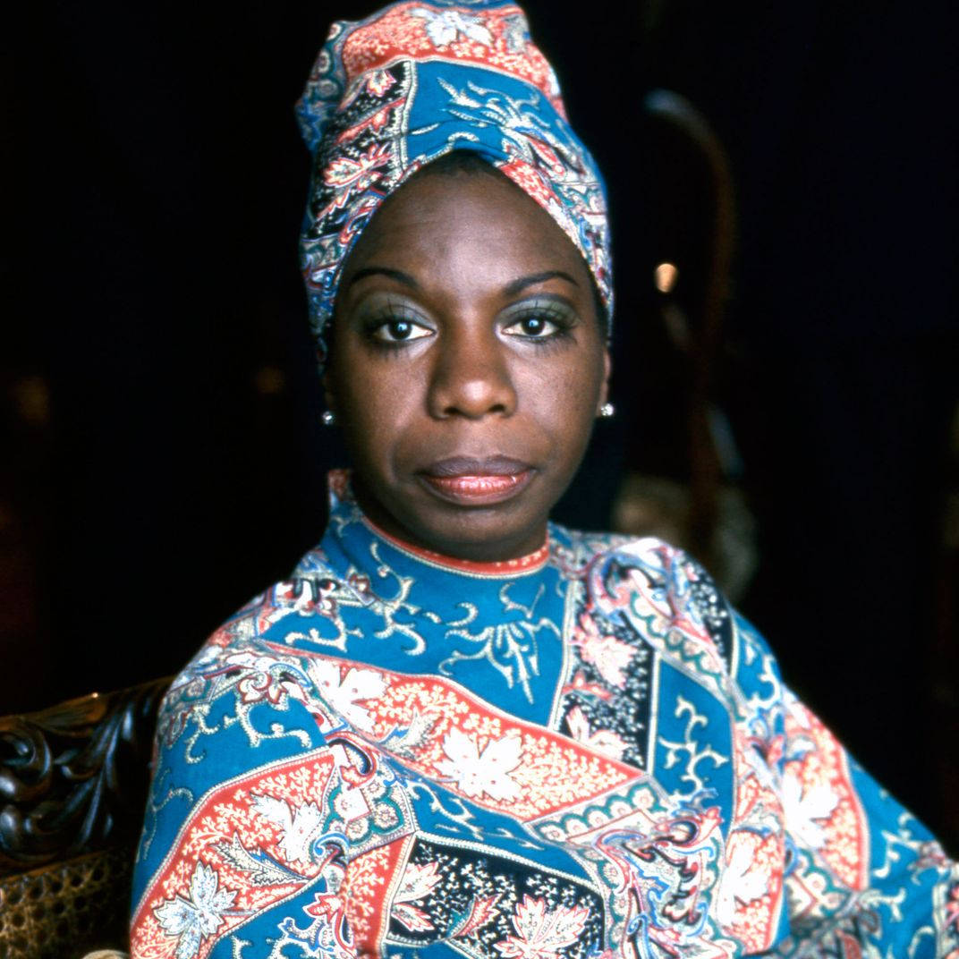 Nina Simone, vibrant blue red and white patterned attire, dark background, SD Desktop Wallpaper