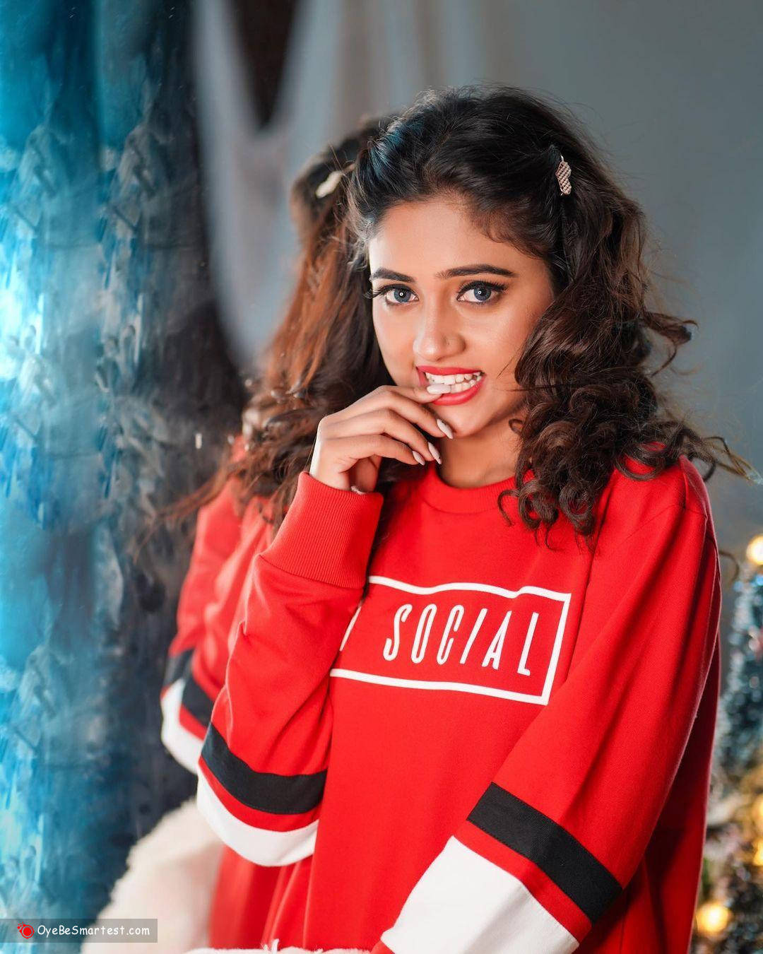 Nisha Guragain, red 'SOCIAL' sweatshirt, textured blue backdrop, HD Phone Wallpaper